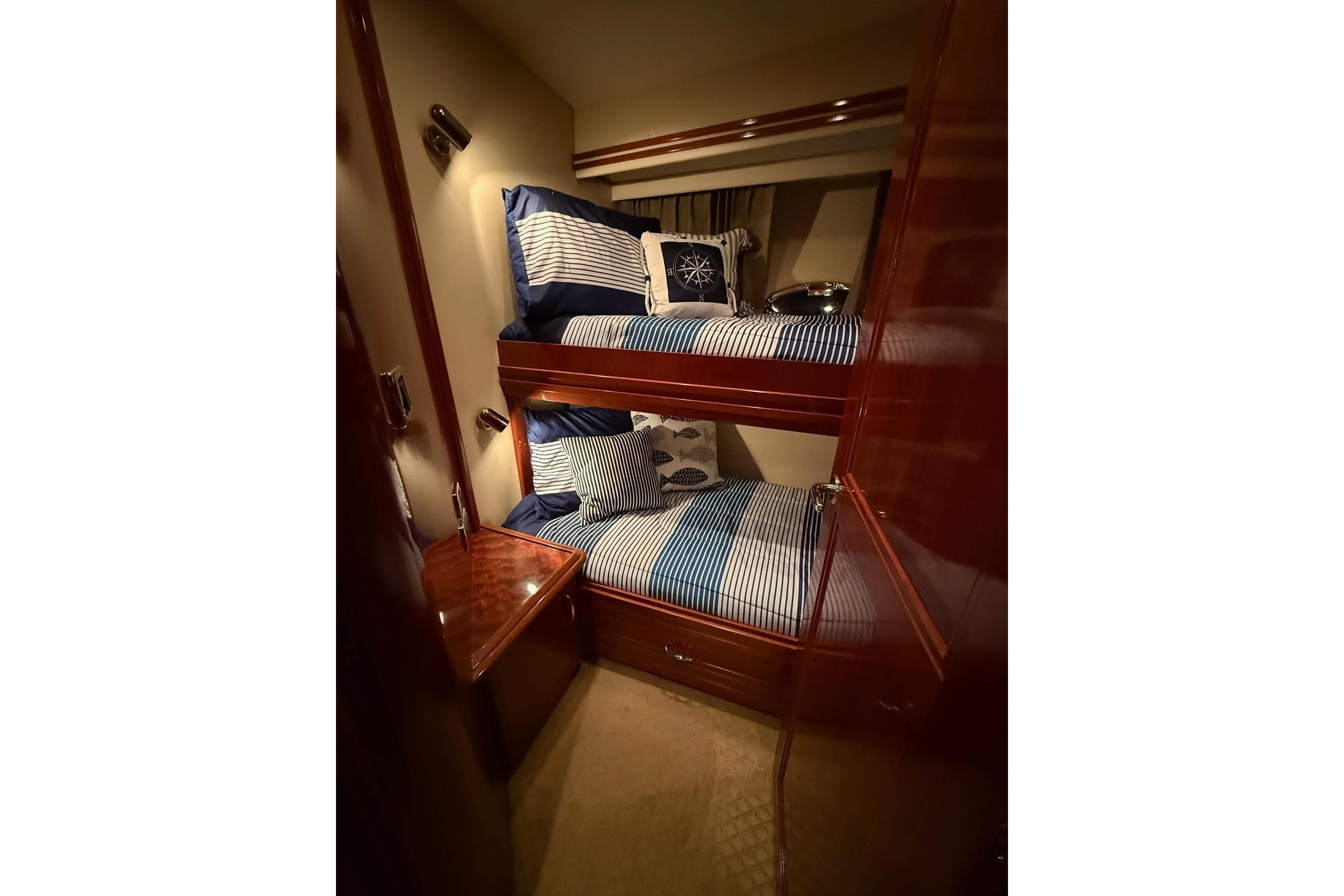 Luxurious 2006 Carver 56 Voyager yacht cabin with cozy bunk beds and nautical decor.
