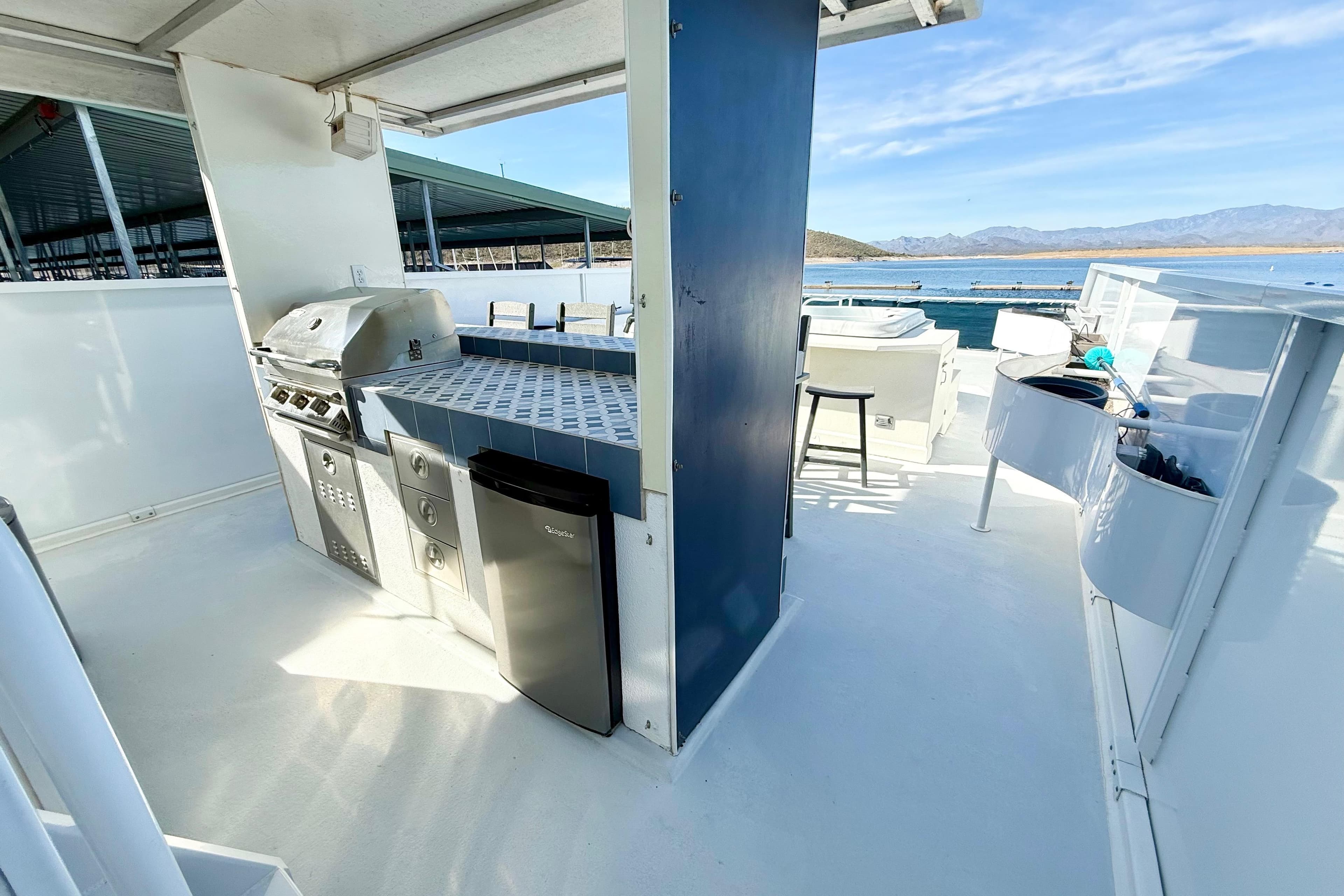 Outdoor kitchen on 2005 Twin Anchors 6816 Arizona Edition Yacht House, featuring grill and mini fridge.