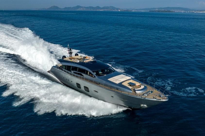 Luxurious 2013 Pershing 108 yacht cruising on open sea with scenic coastline.