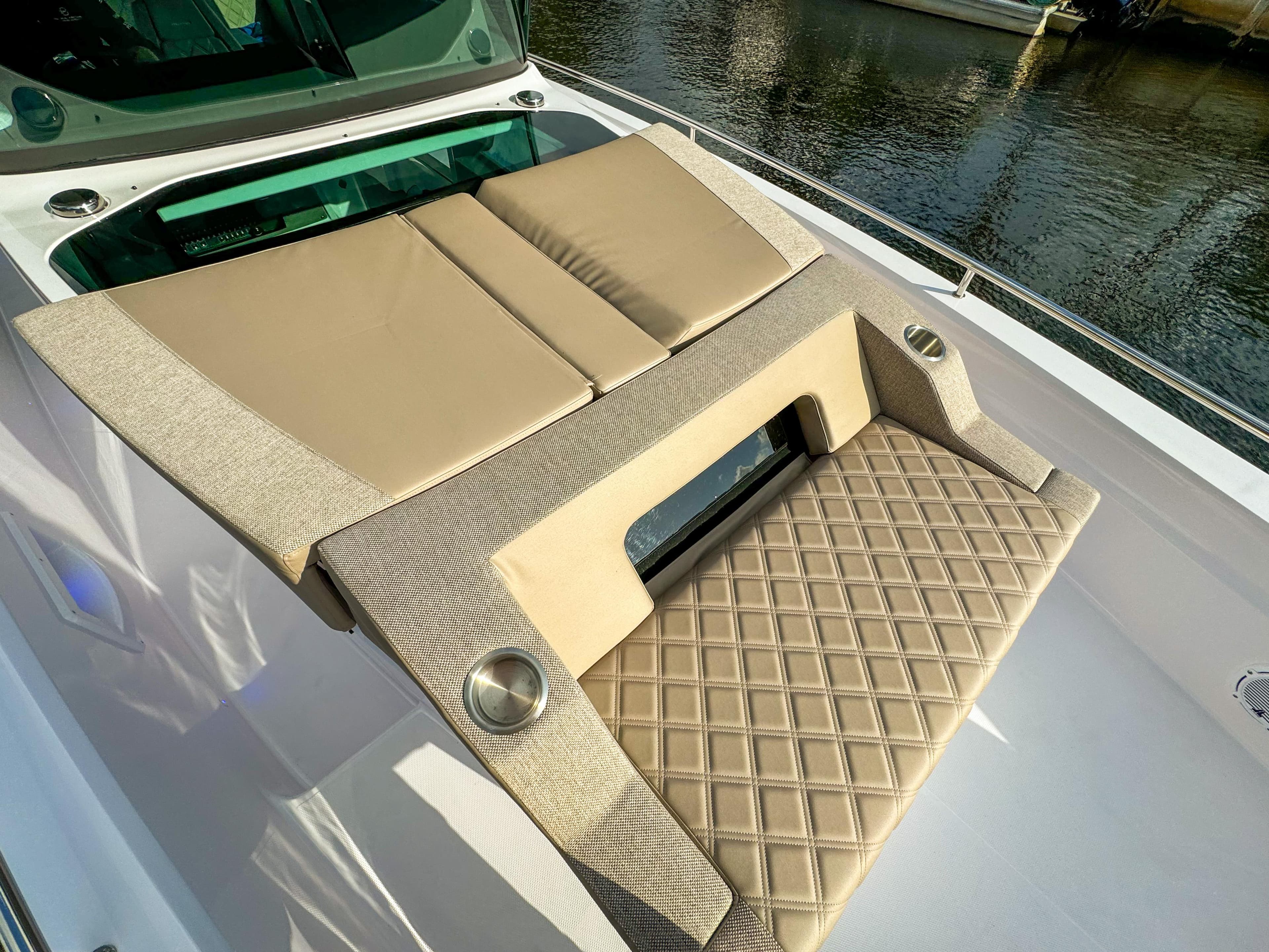 Luxurious sunbed on 2024 Axopar 37XC CROSS CABIN, featuring beige cushions and diamond-patterned upholstery.