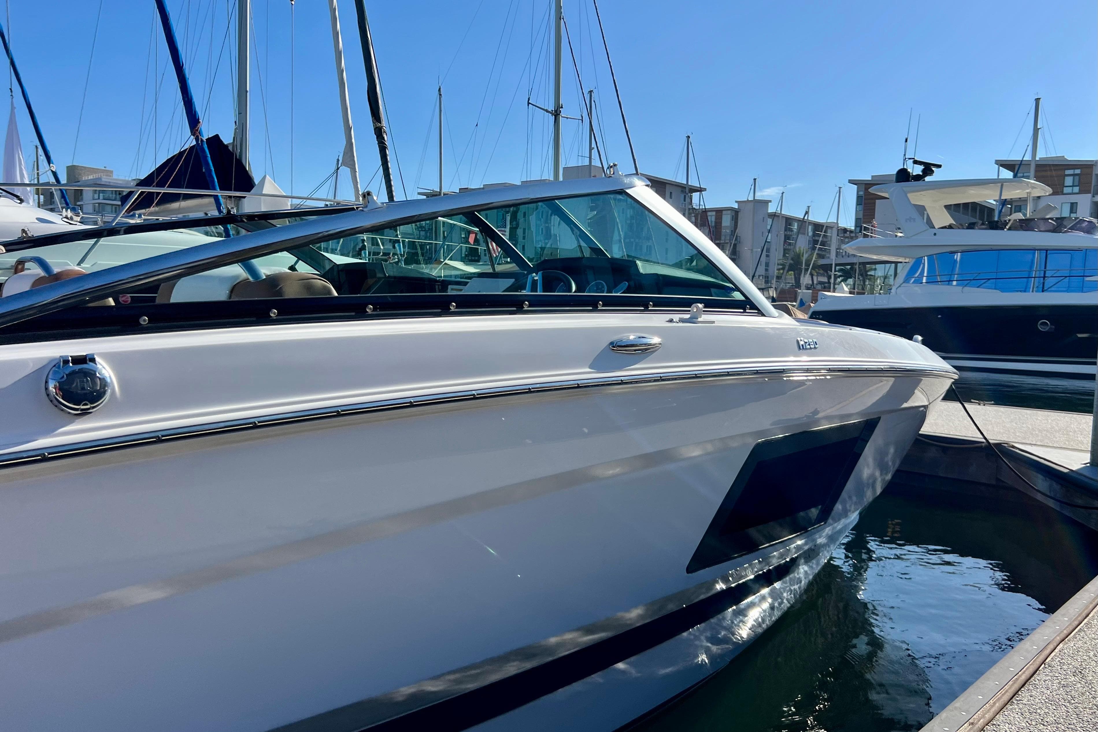 2019 Four Winns Horizon H290 boat docked in a marina under clear blue skies.
