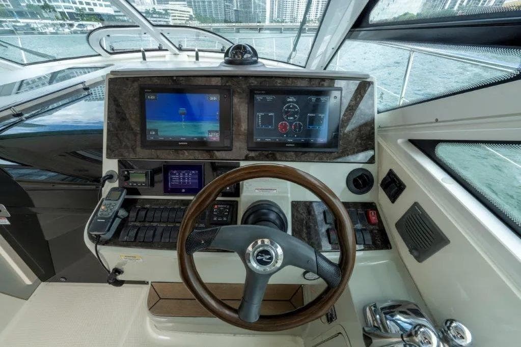 2009 Sea Ray 43 Sundancer helm with dual displays and wooden steering wheel.