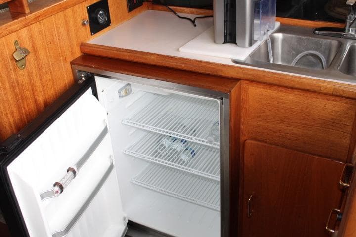 1988 Tollycraft 30 Sport Cruiser galley with open fridge and sink.