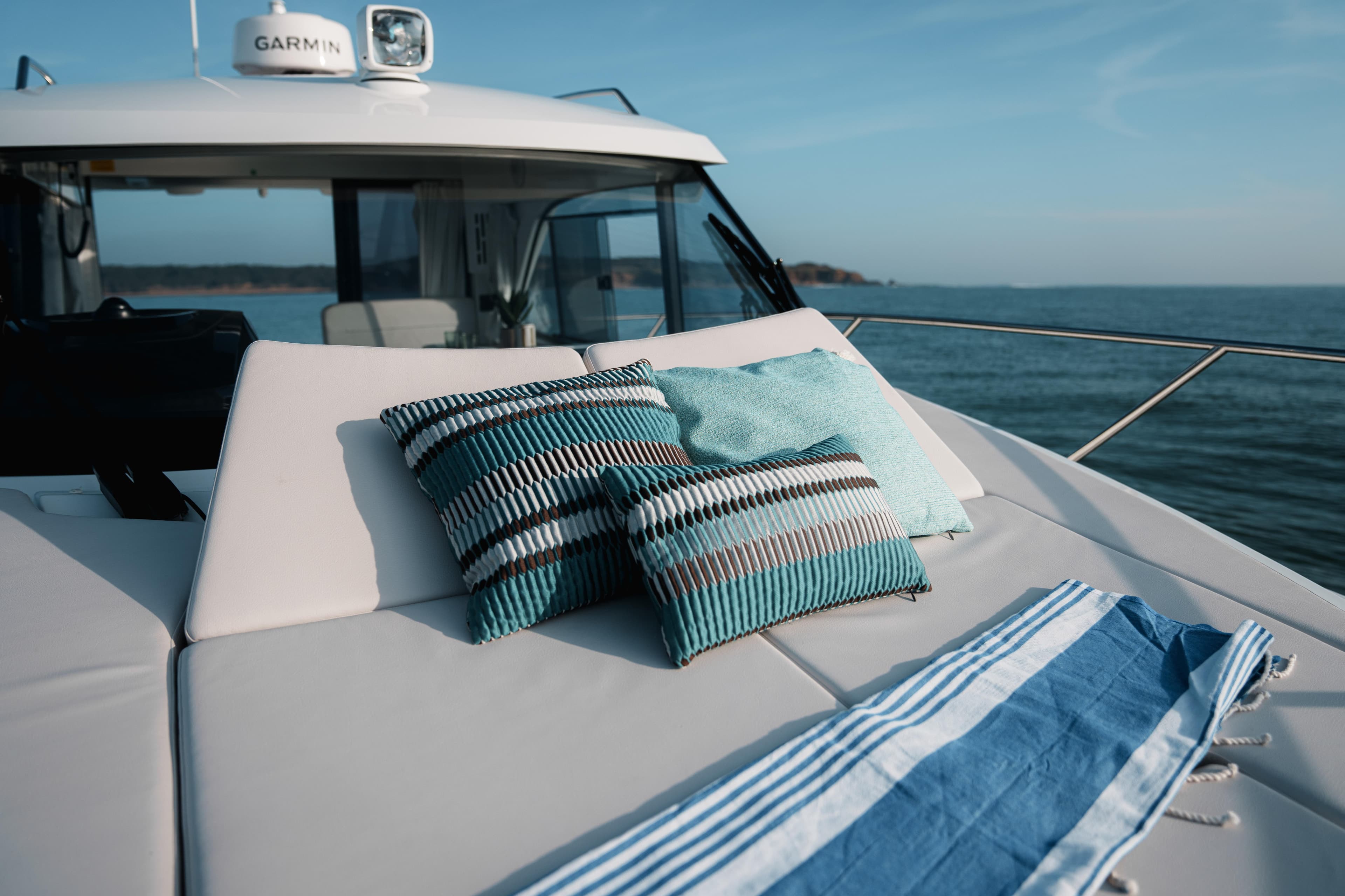 2026 Beneteau Antares 9 V2 yacht with cushions and towel on deck, ocean view.