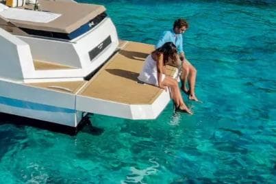 Couple relaxing on De Antonio Yachts D36, 2025 model, enjoying clear turquoise waters.