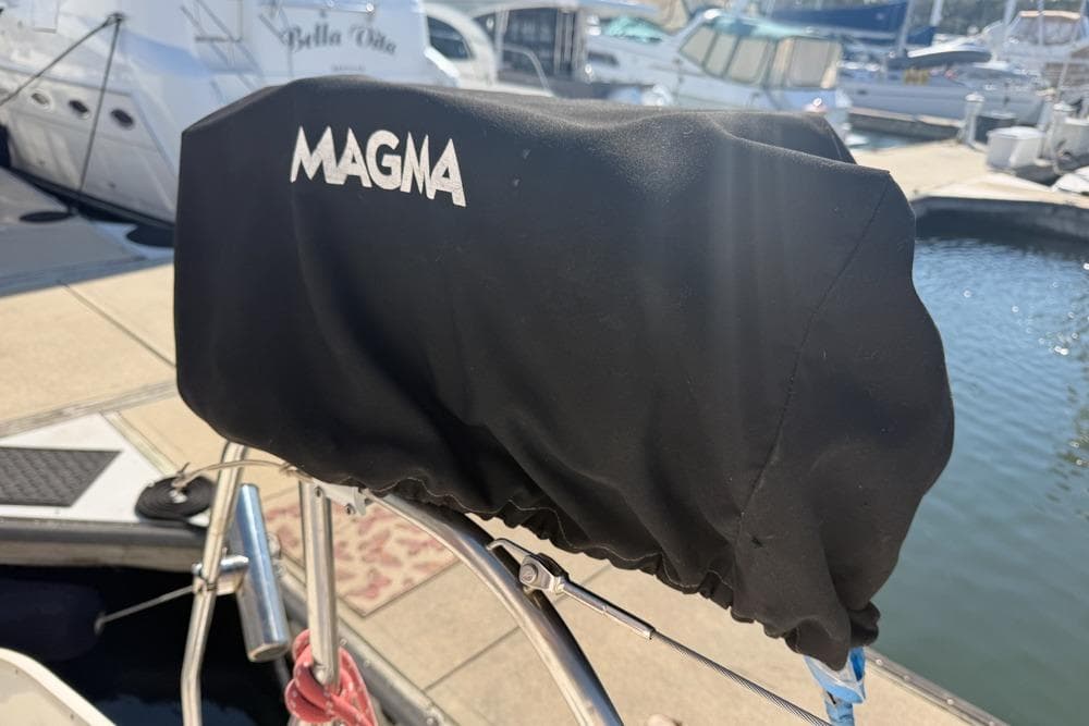 Covered Magma grill on Leopard 38 catamaran, docked at marina, sunny day.