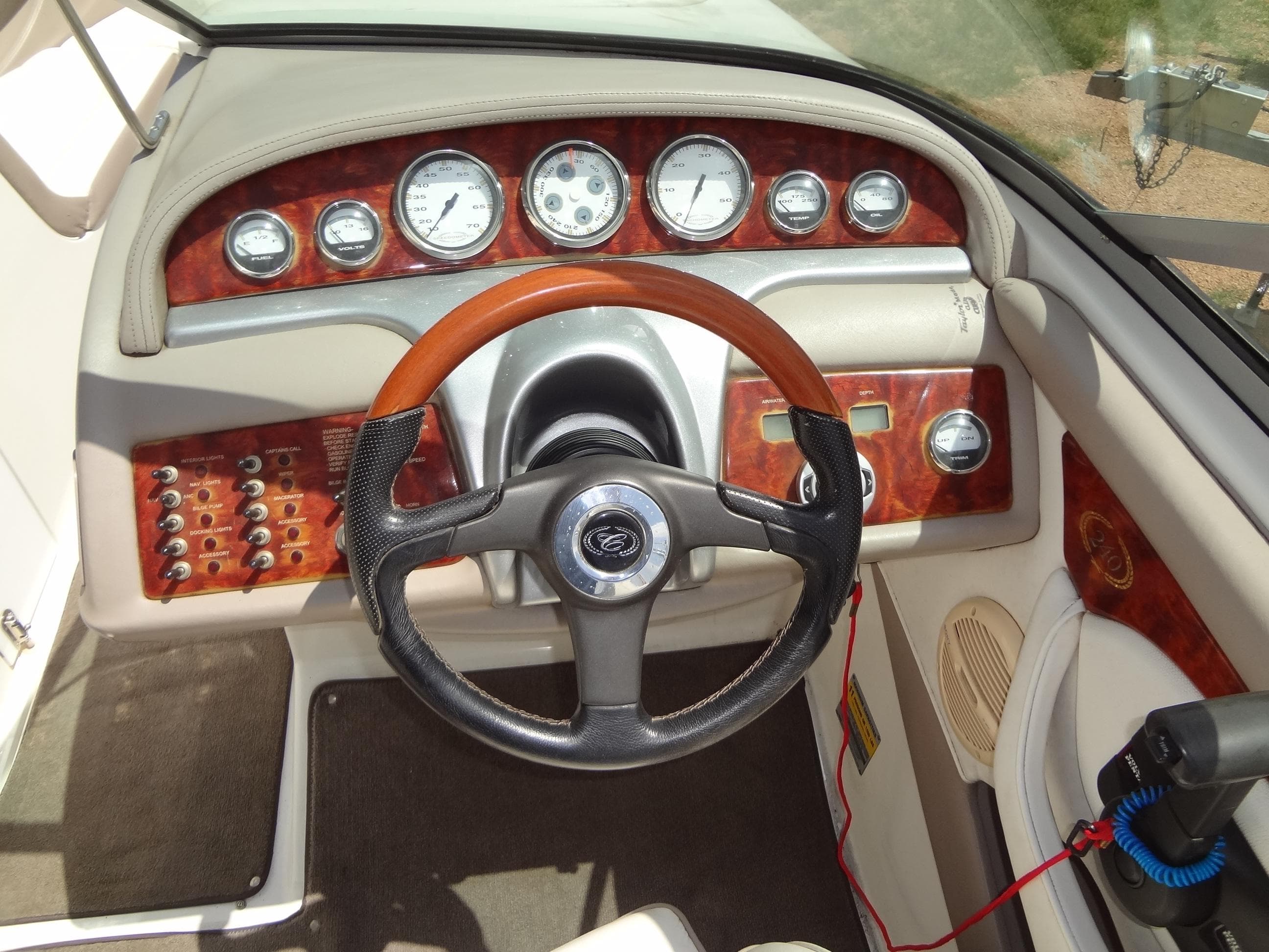 Dashboard of a 2004 Cobalt 240 boat with wood accents and steering wheel.