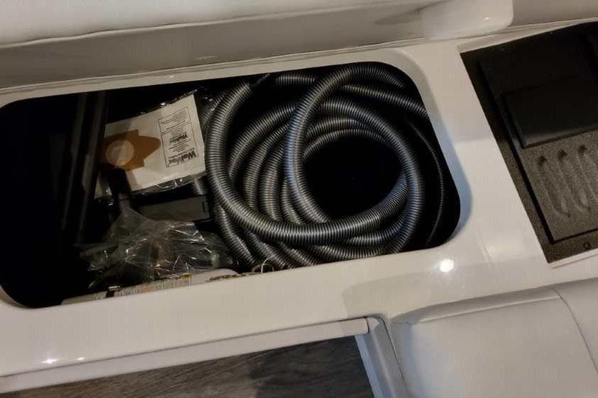 Storage compartment in 2023 Formula 380 Super Sport Crossover OB with coiled hose and accessories.