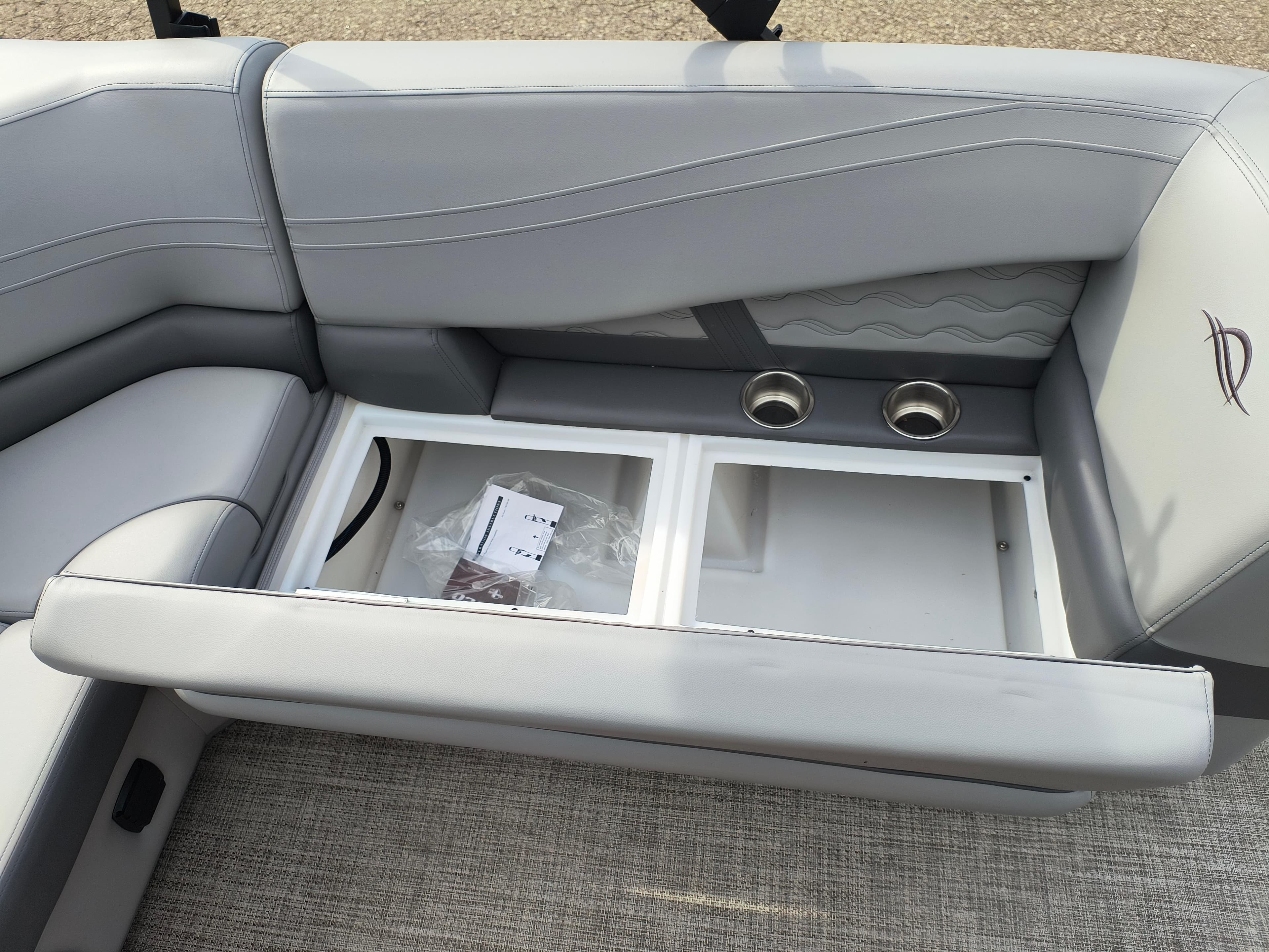 2025 SunCatcher Fusion 322C boat seat with storage compartment and cup holders.