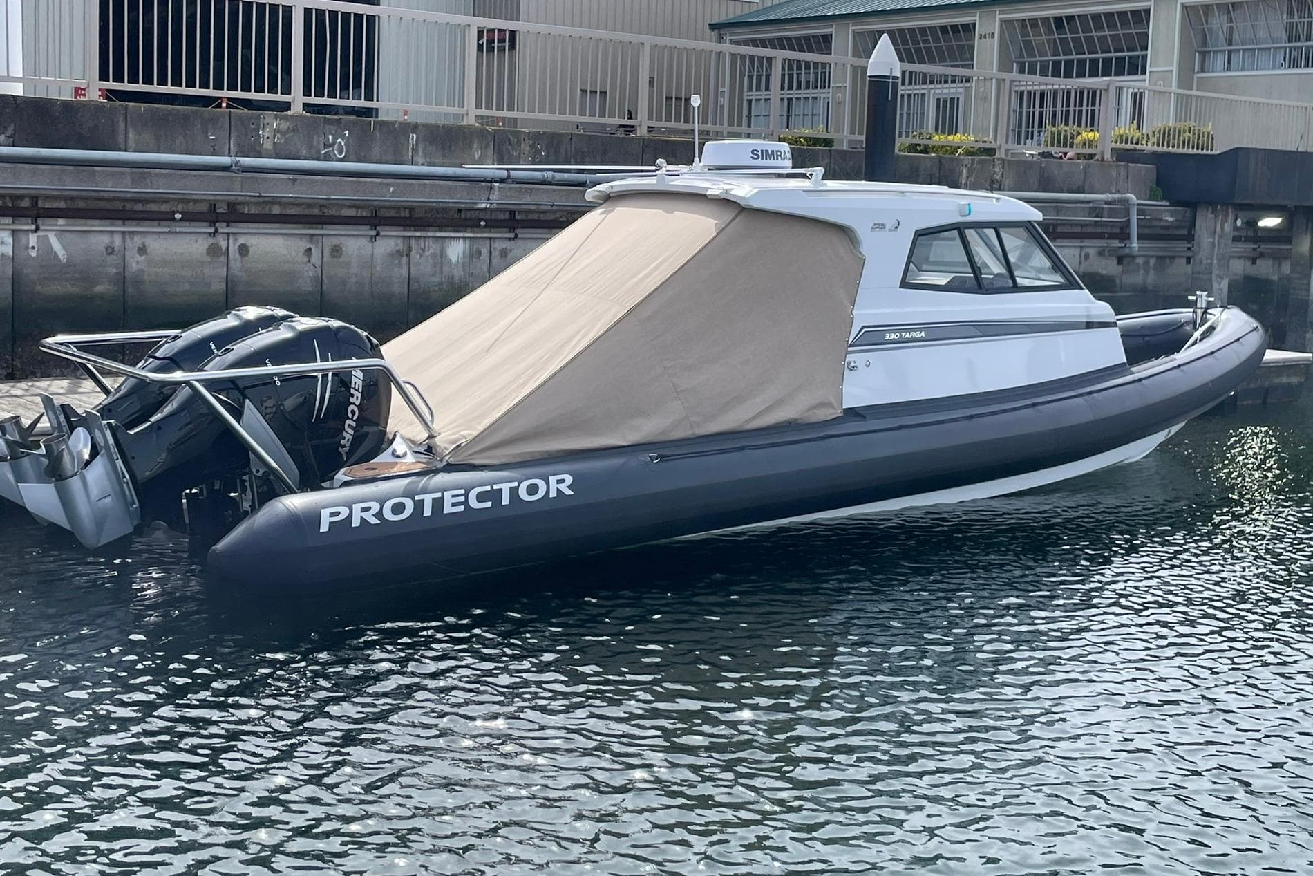 2024 Protector 330 Targa boat with twin 400 HP engines docked in marina.