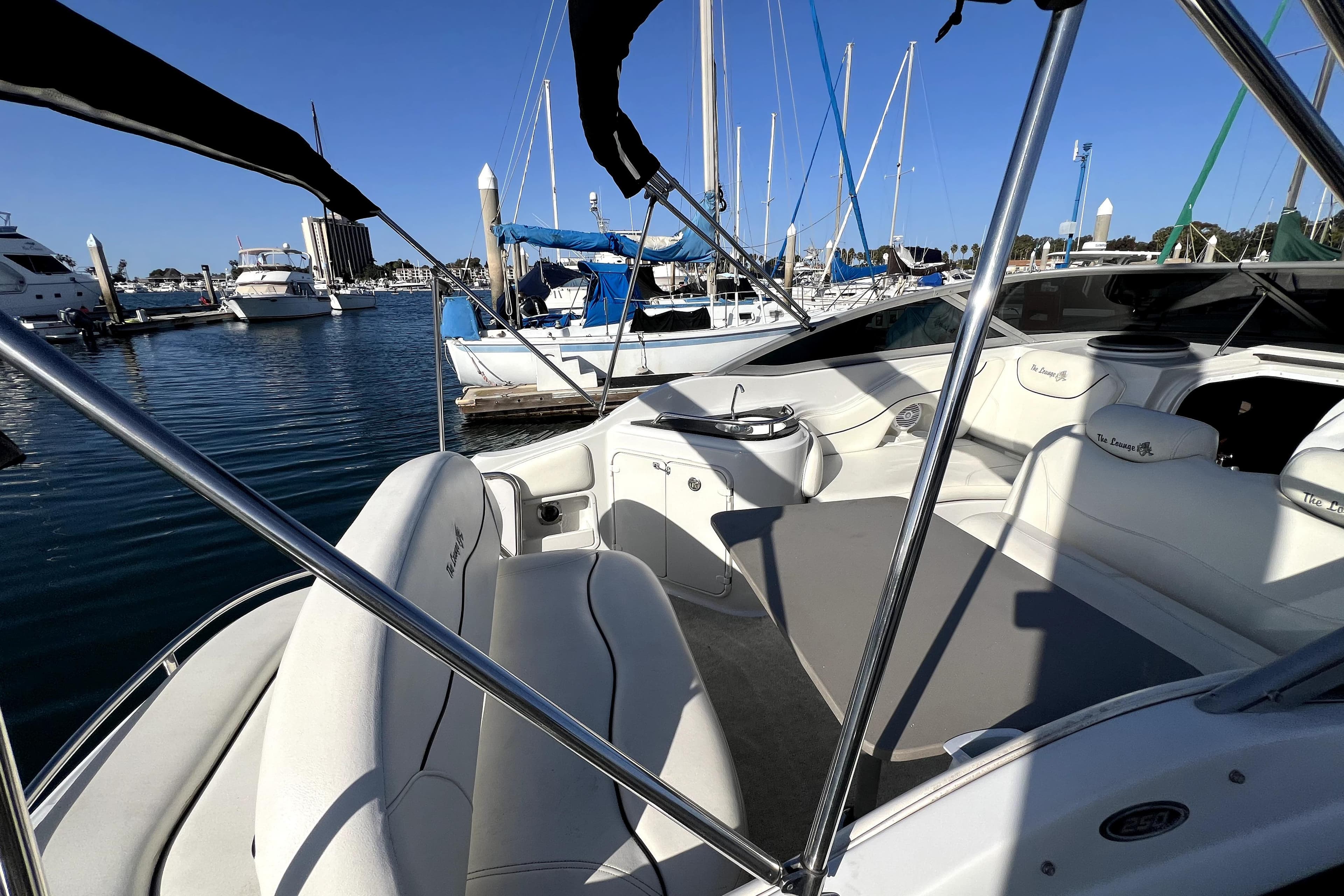 2004 Crownline 250 CR boat interior at marina, featuring white seating and sleek design.