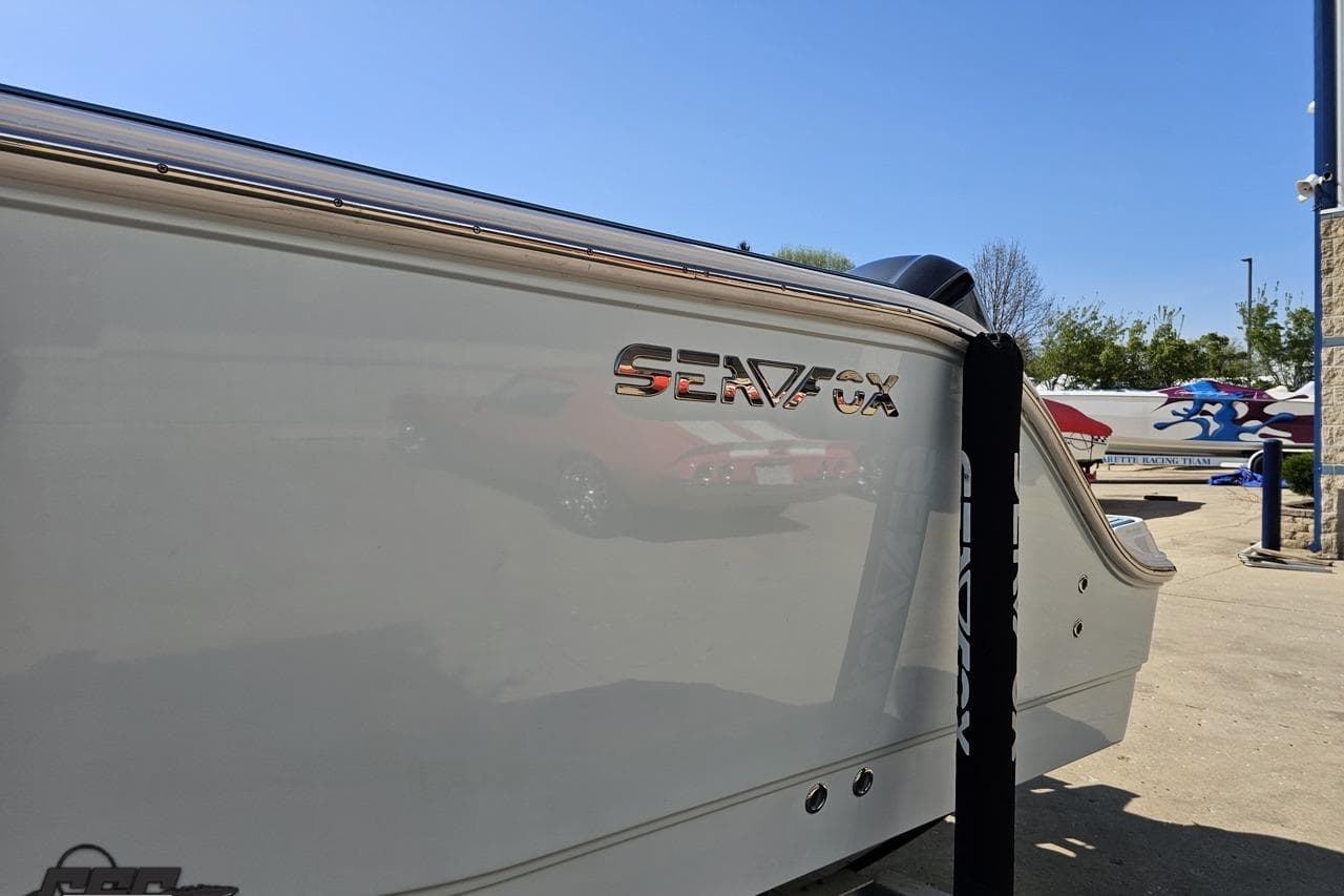 2013 Sea Fox 286 Commander boat side view with logo in a sunny marina.