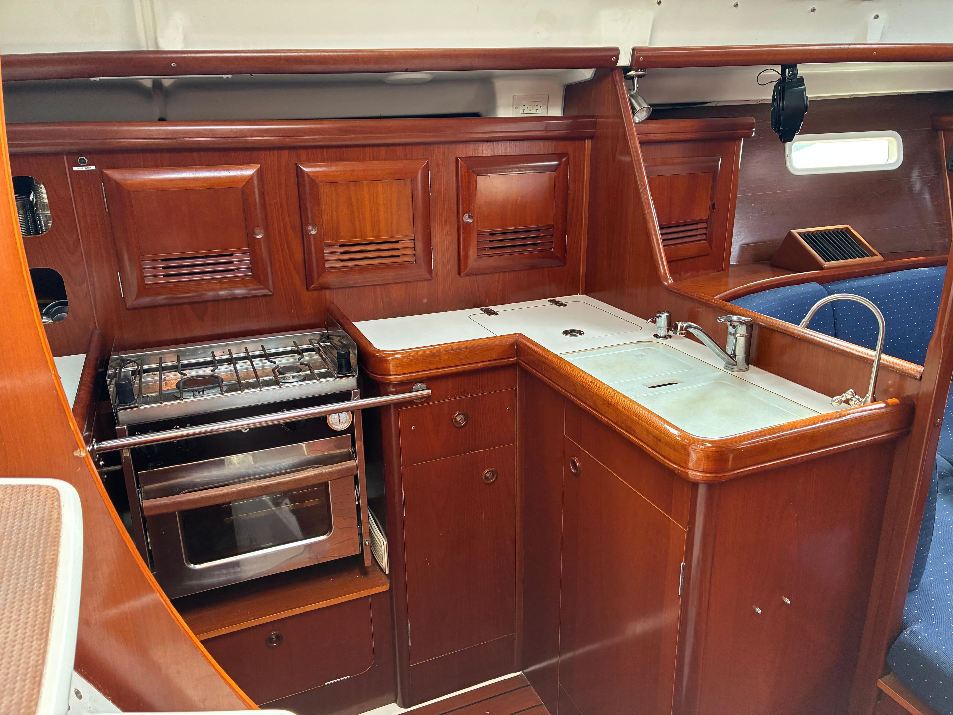 2003 Beneteau Oceanis Clipper 393 yacht kitchen with wood cabinetry and stainless steel appliances.