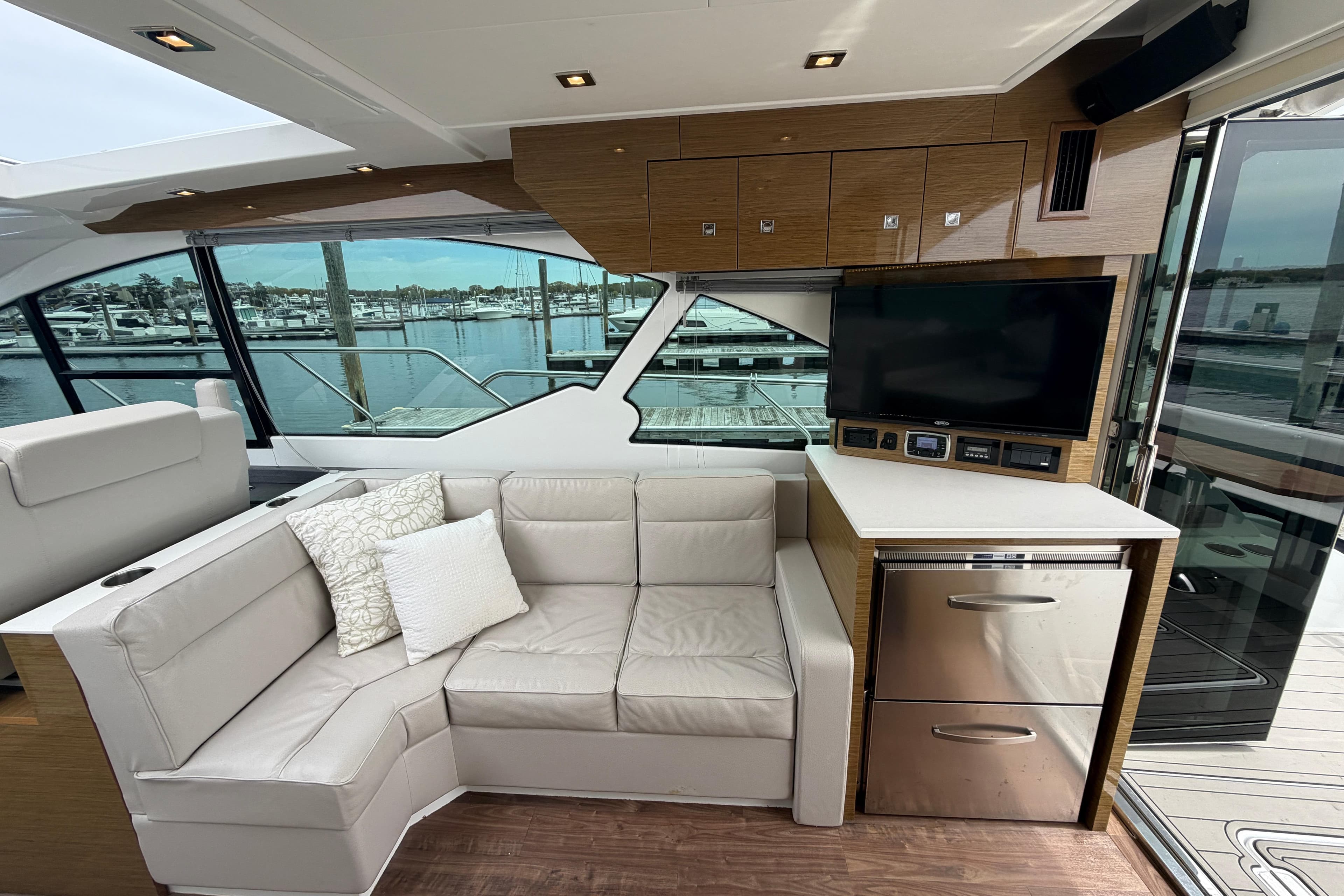 Luxurious interior of 2018 Cruisers Yachts 50 Cantius with leather seating and waterfront view.