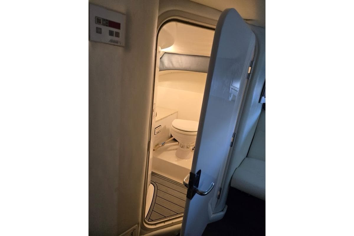 Interior view of a 2007 Cobalt 343 boat bathroom with open door.