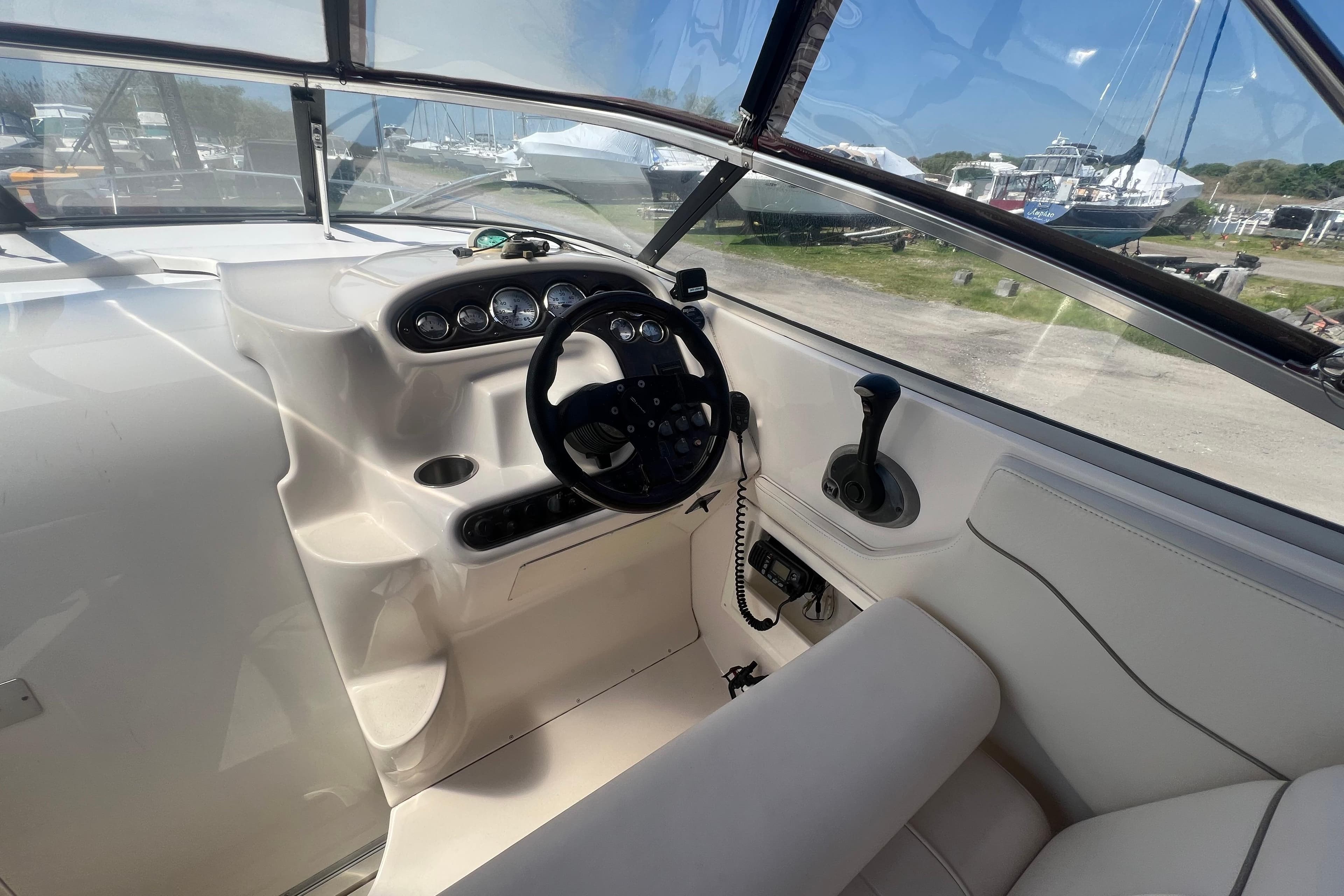 Interior cockpit of a 2002 Monterey 262 Cruiser boat with steering wheel and controls.