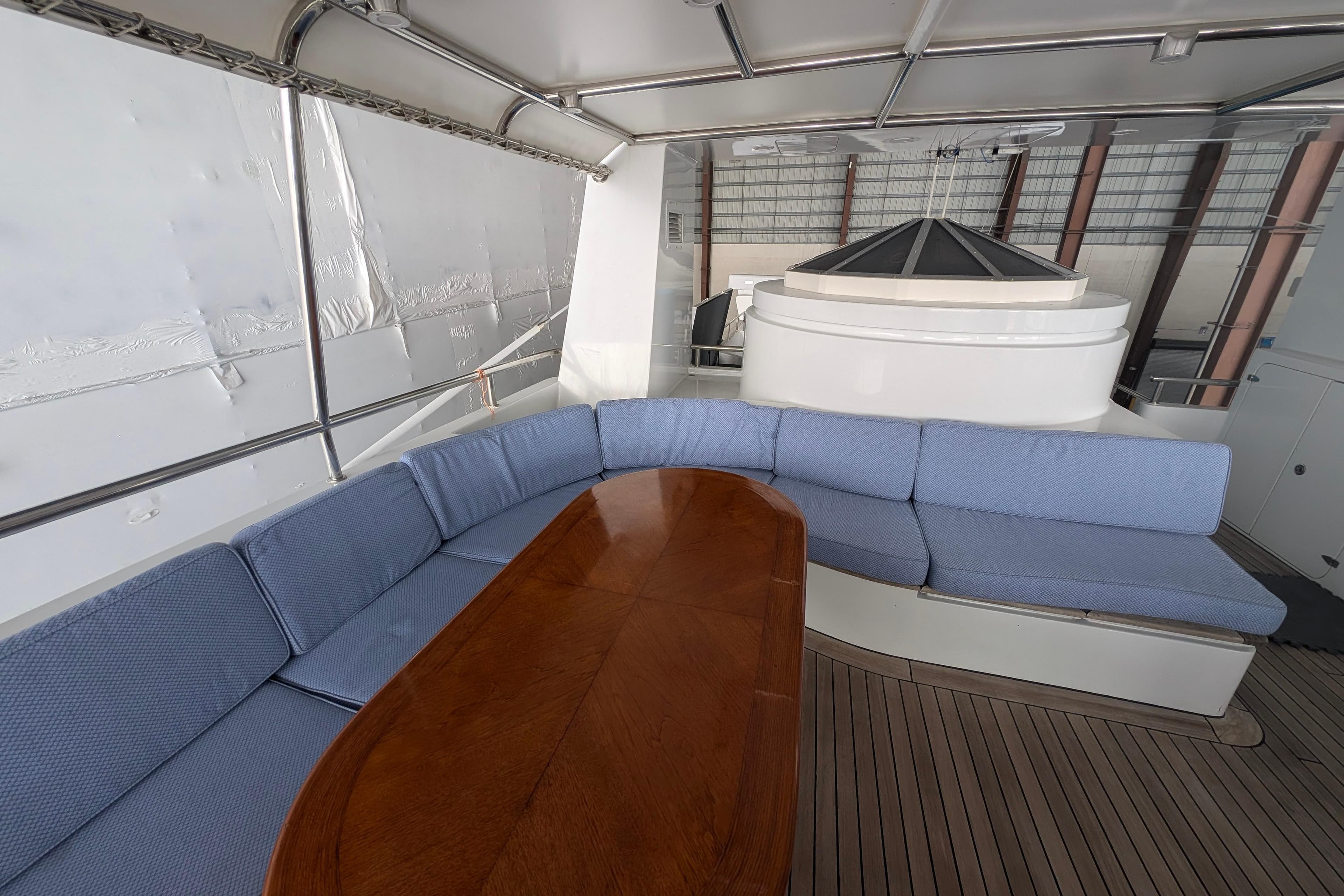 Luxurious 2001 Doggersbank yacht interior with blue cushioned seating and wooden table.