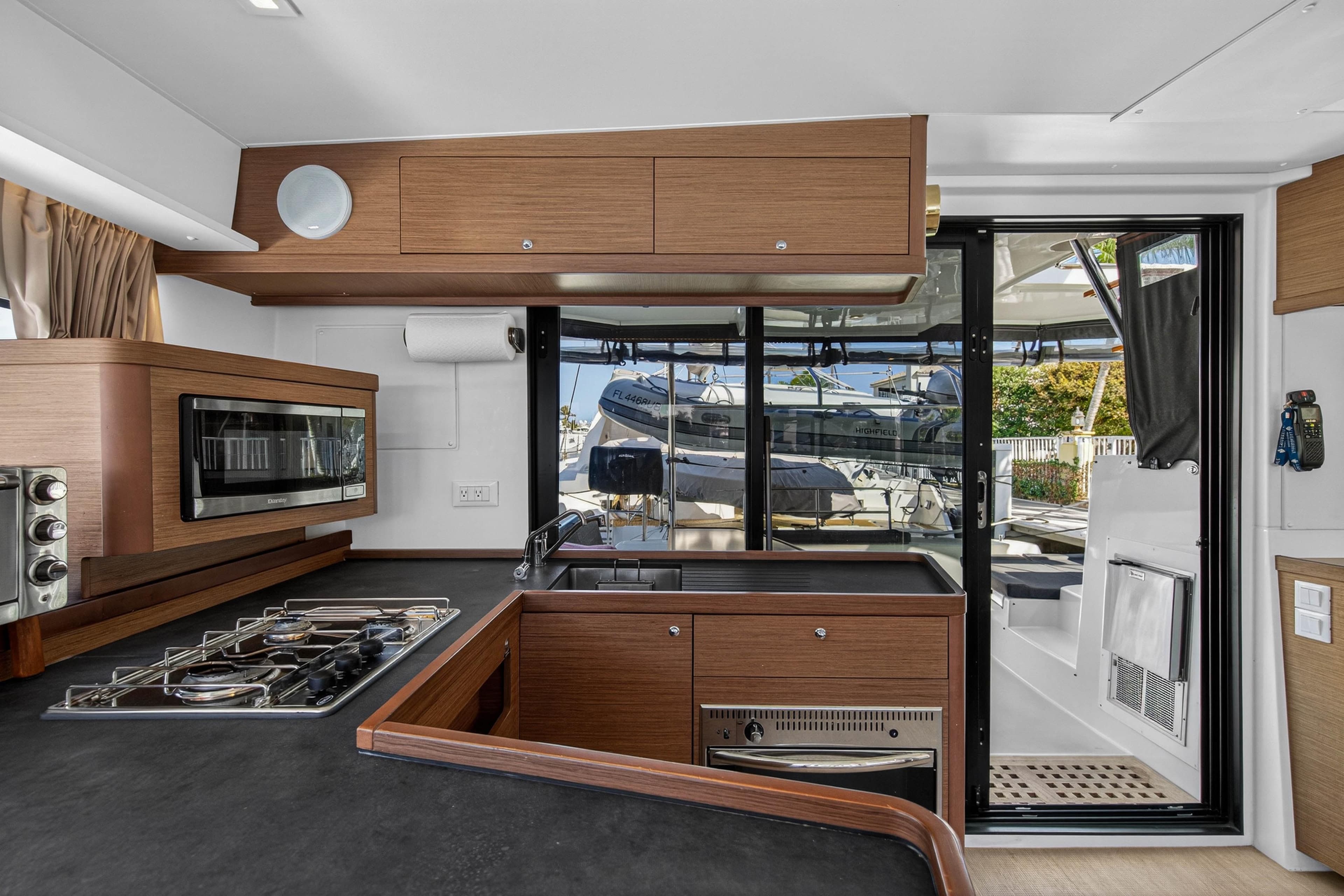 Modern kitchen interior of 2019 Lagoon 42 yacht with stove, oven, and outdoor view.