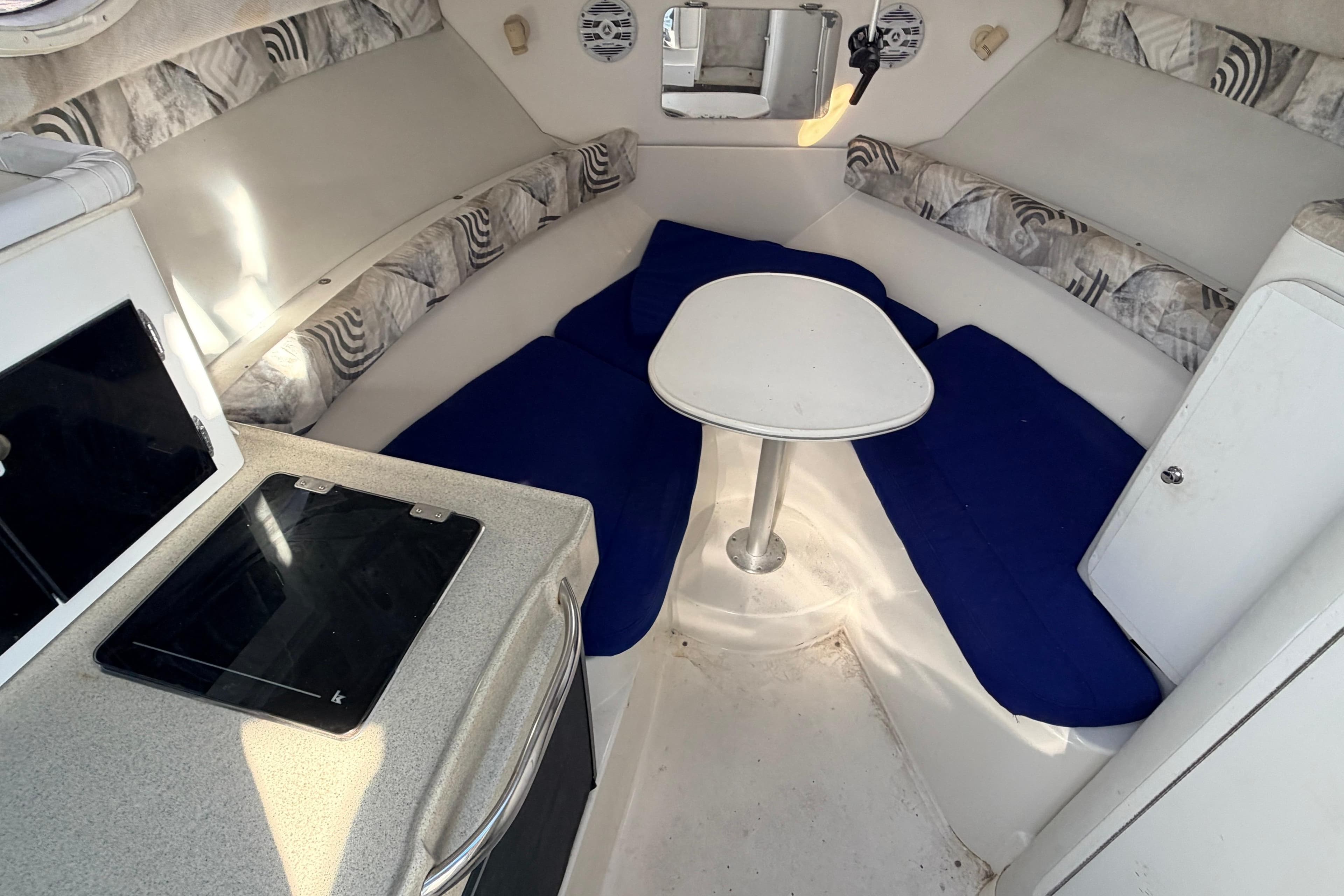 Interior of 2000 Wellcraft 270 Coastal O/B boat with seating and table.