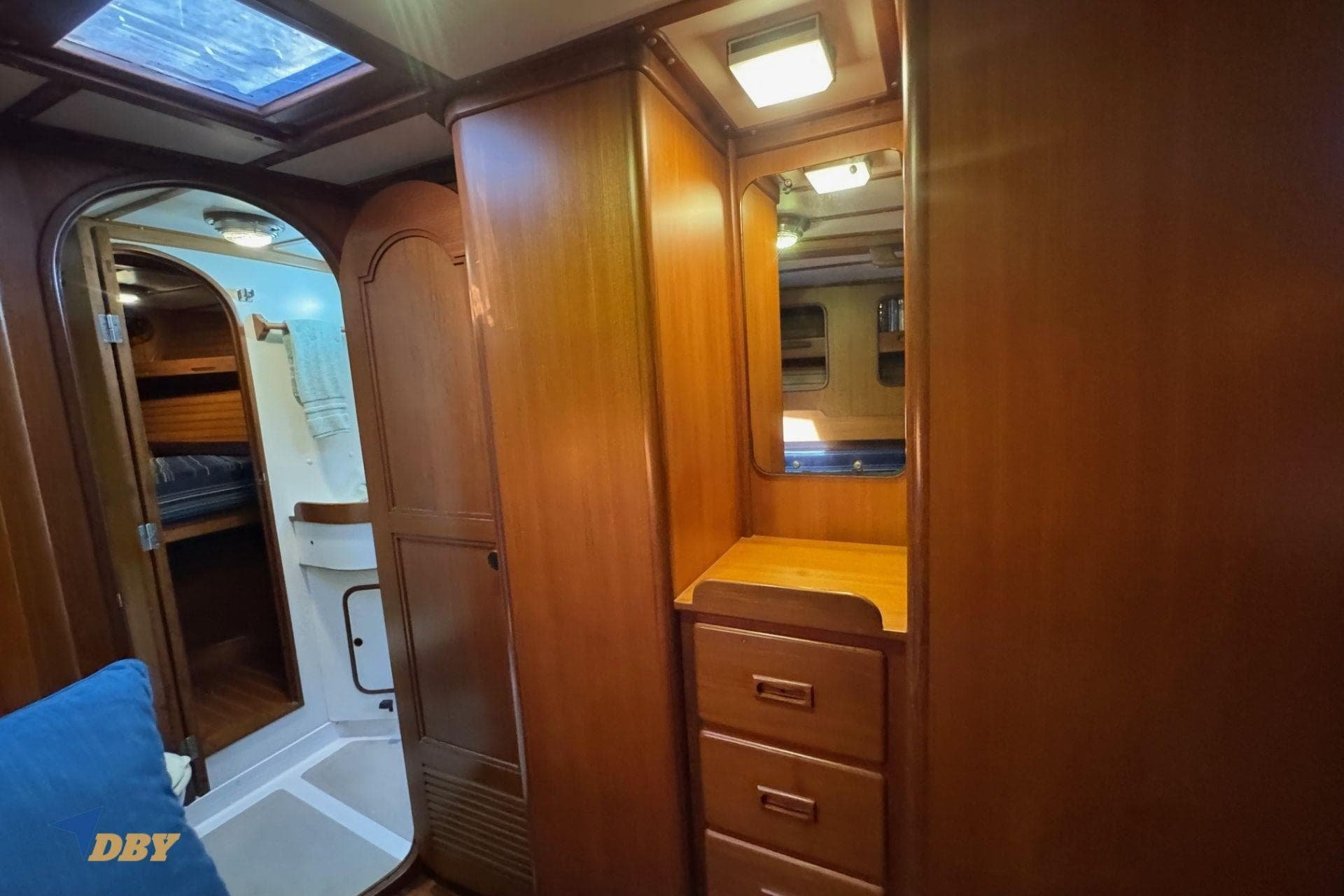 Interior of 1983 Mason 53 yacht with wooden cabinetry and mirror.