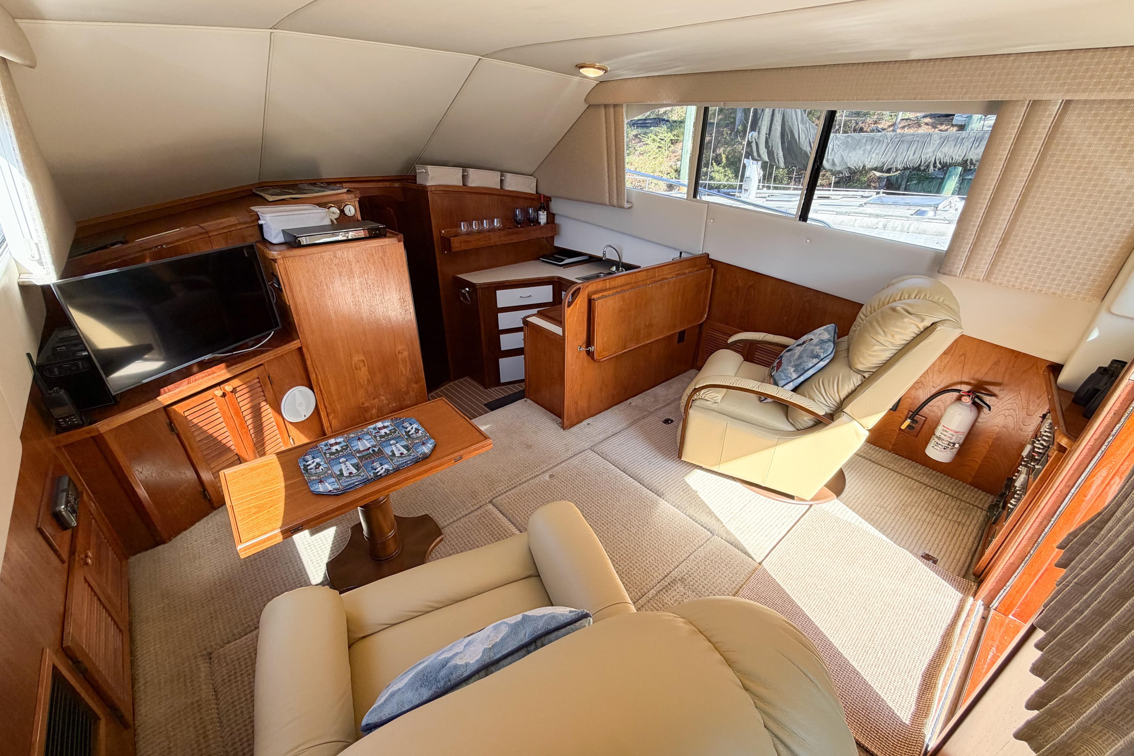 Interior of a 1988 Pacemaker 36 Convertible yacht with cozy seating and wooden cabinetry.