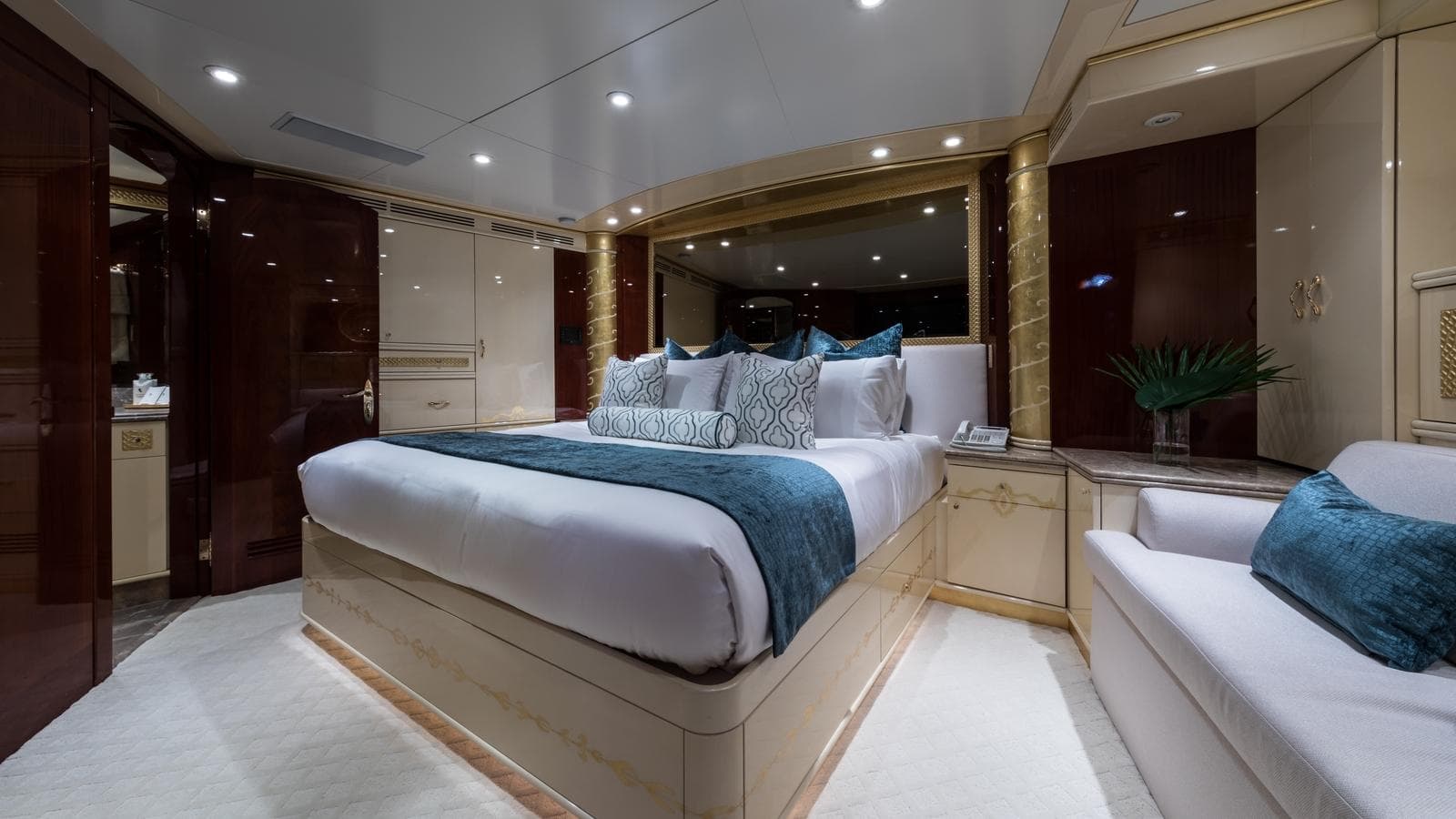 Luxurious yacht bedroom interior with elegant decor, featuring a large bed and plush seating.