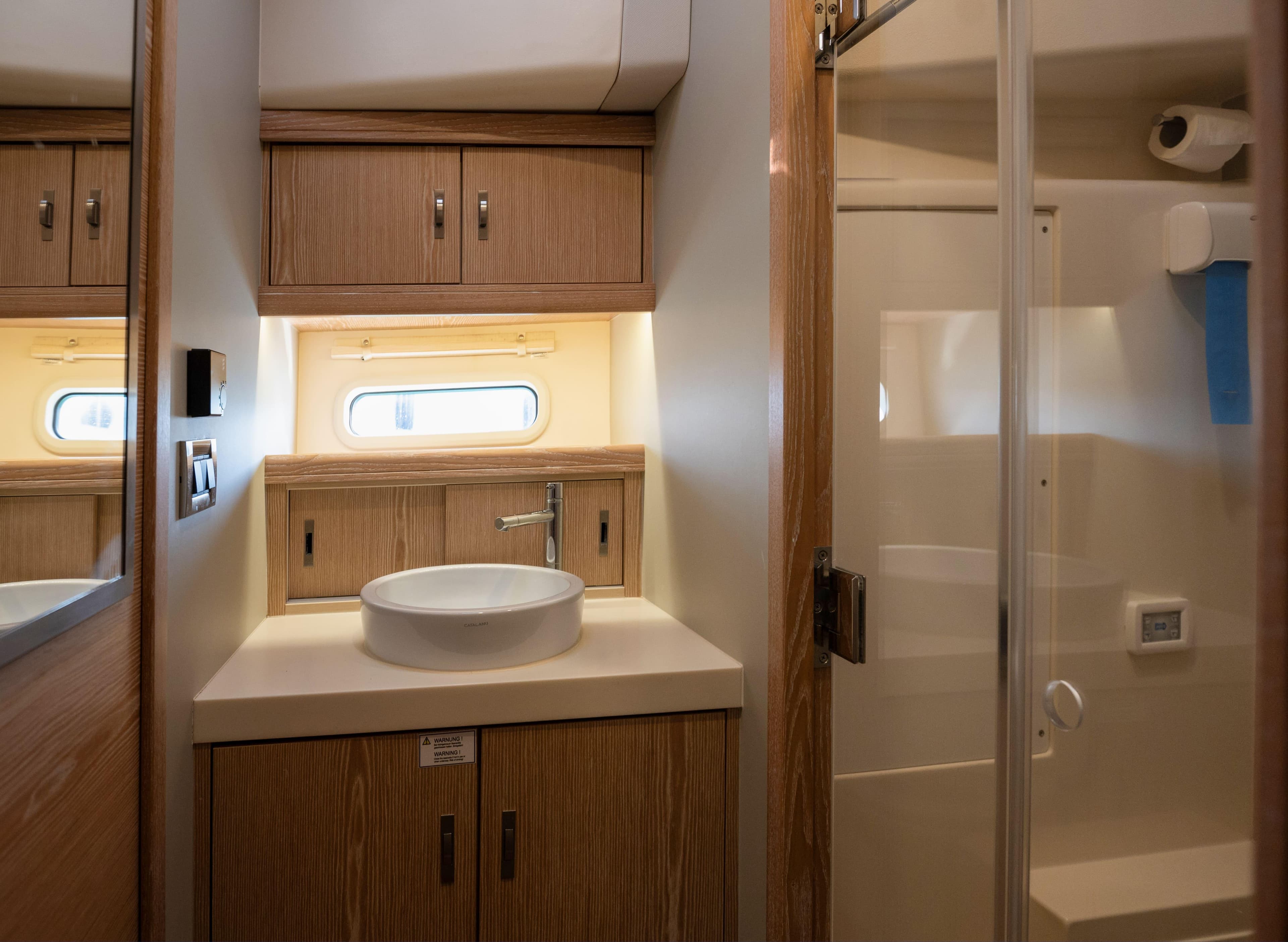 Luxurious bathroom in 2016 Moody Decksaloon 54 yacht with modern fixtures and wood cabinetry.