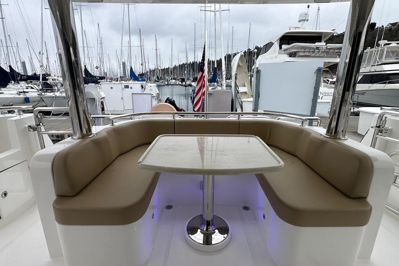 Luxurious seating area on 2024 Northwest 55 yacht, docked at marina with boats.