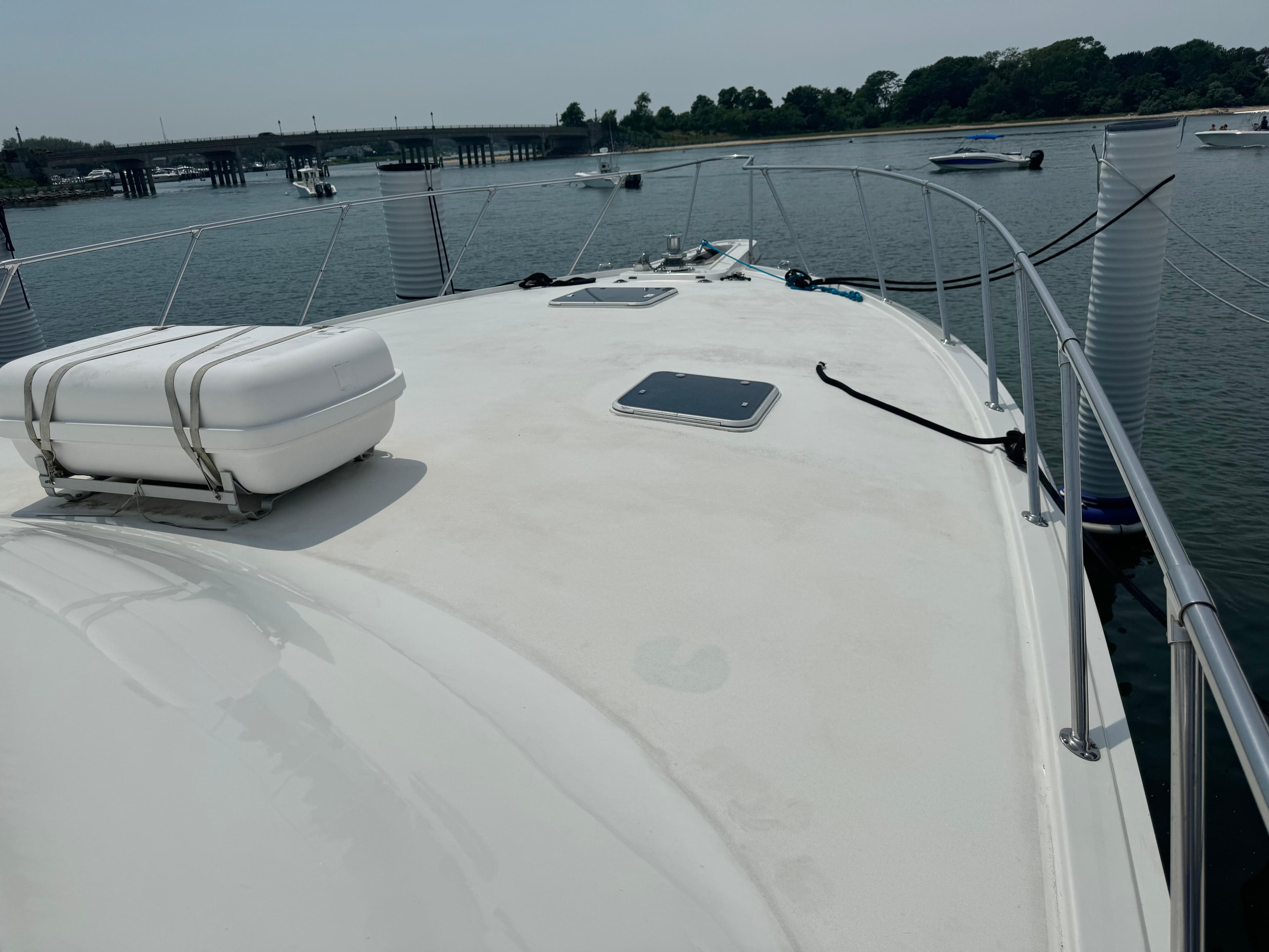 1994 Hatteras 54 Convertible yacht deck with railing and hatch, docked in a serene marina.