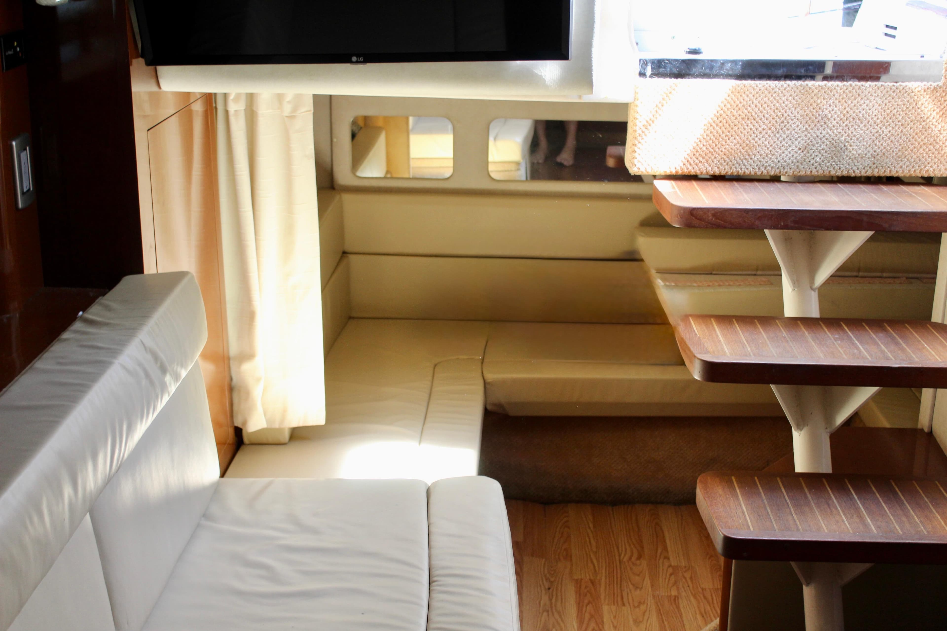 Interior of 2011 Sea Ray Sundancer 350 yacht with cozy seating and wooden steps.