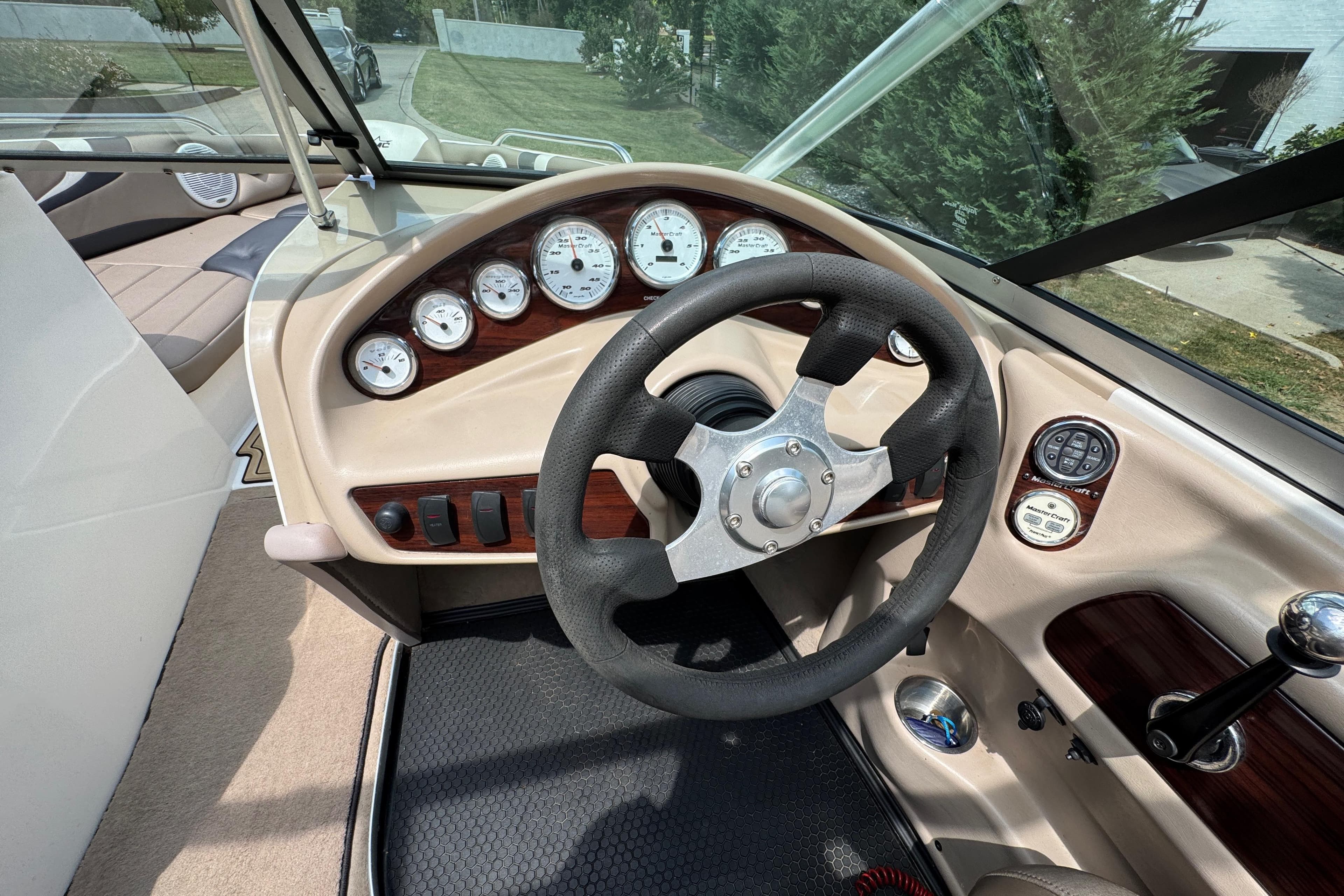 2002 MasterCraft ProStar 209 boat dashboard with steering wheel and gauges.