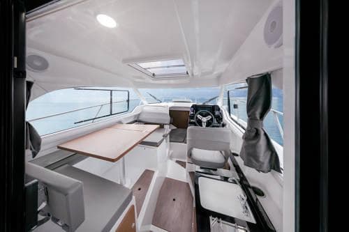 Interior of 2024 Beneteau Antares 8 V2 boat, featuring modern seating and navigation area.