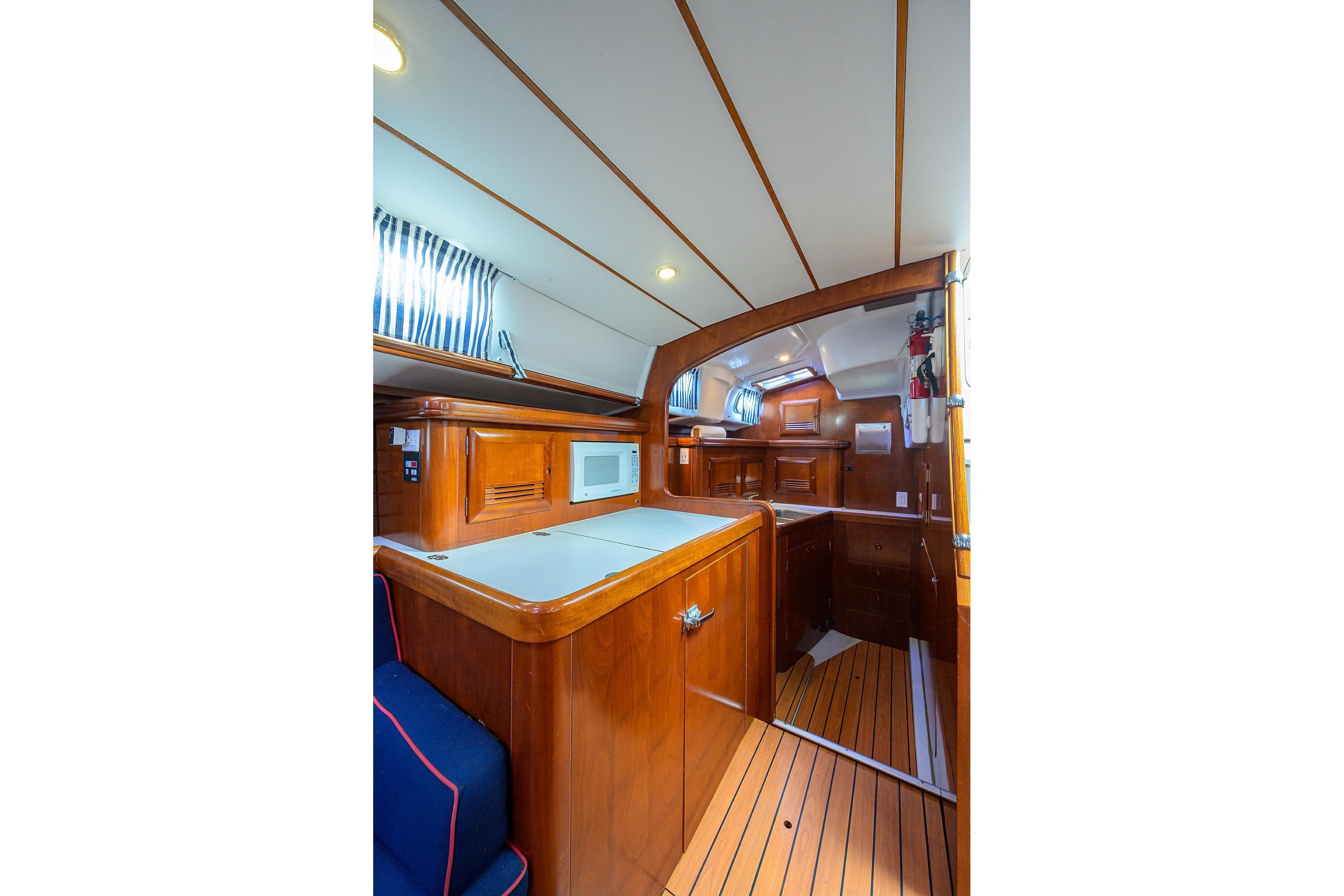 Interior of 2003 Beneteau 50 yacht, featuring wooden cabinetry and modern amenities.