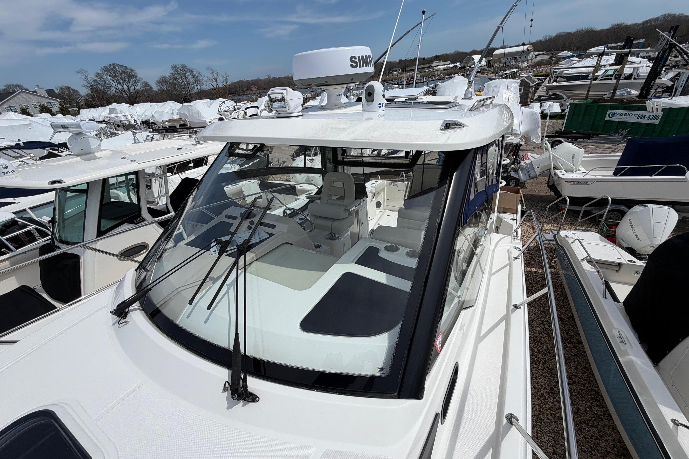 2023 Boston Whaler 325 Conquest boat docked, showcasing sleek design and advanced navigation equipment.