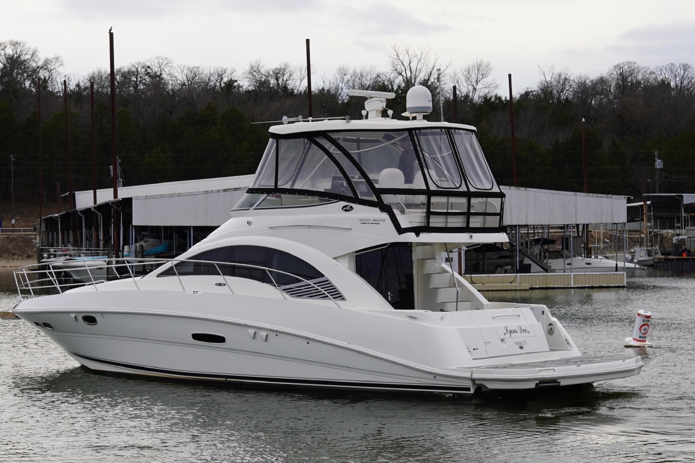 2009 Sea Ray 47 Sedan Bridge yacht docked in a marina, side view.