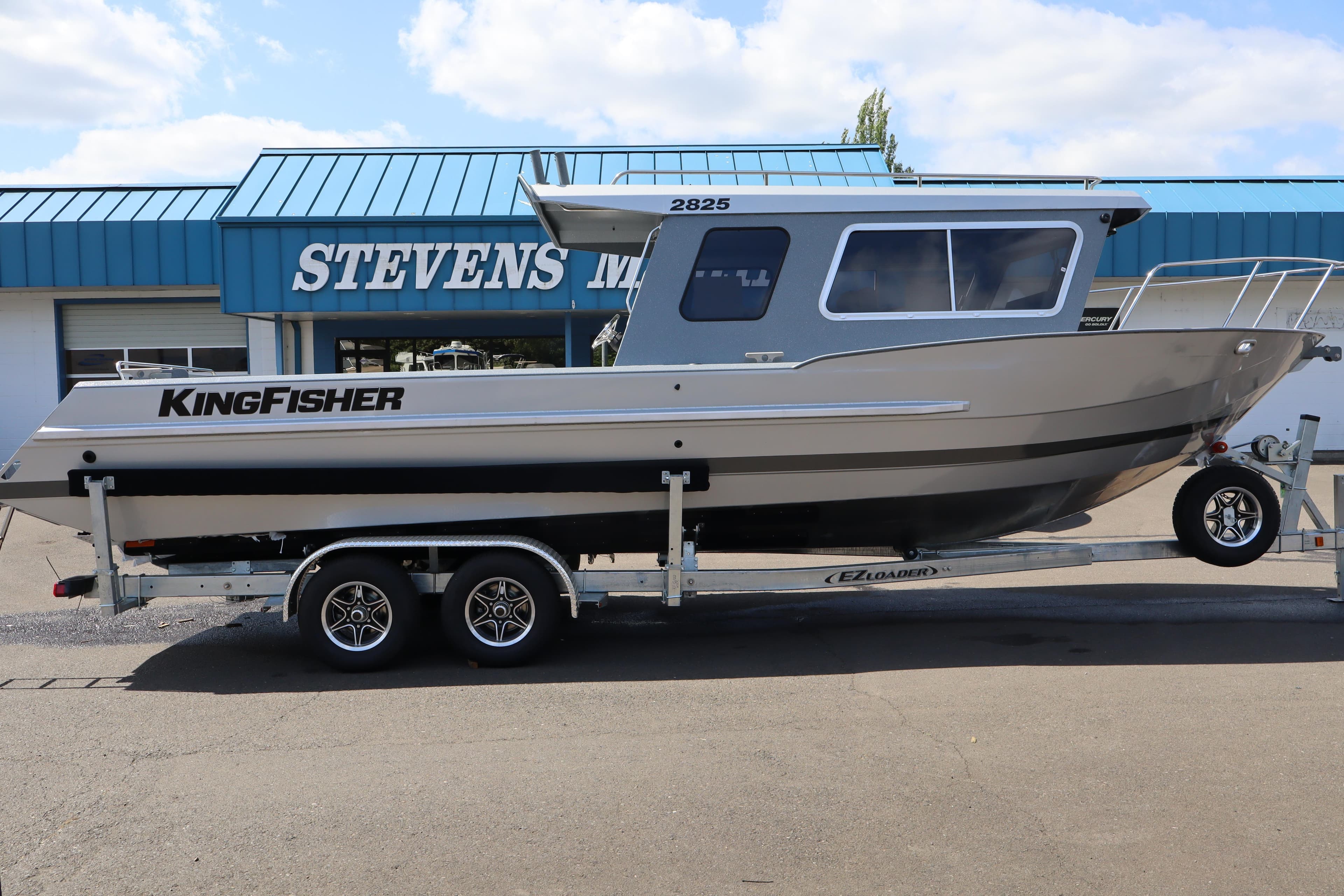 2026 KingFisher 2825 Coastal Express boat on trailer outside Stevens Marine dealership.