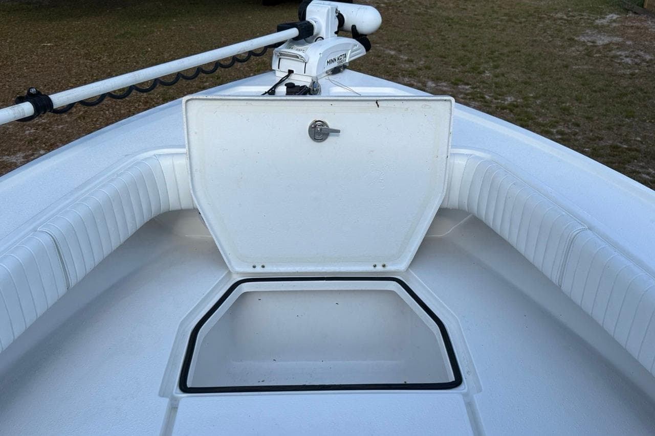 2017 Dorado 25 SE boat with open storage compartment and trolling motor.