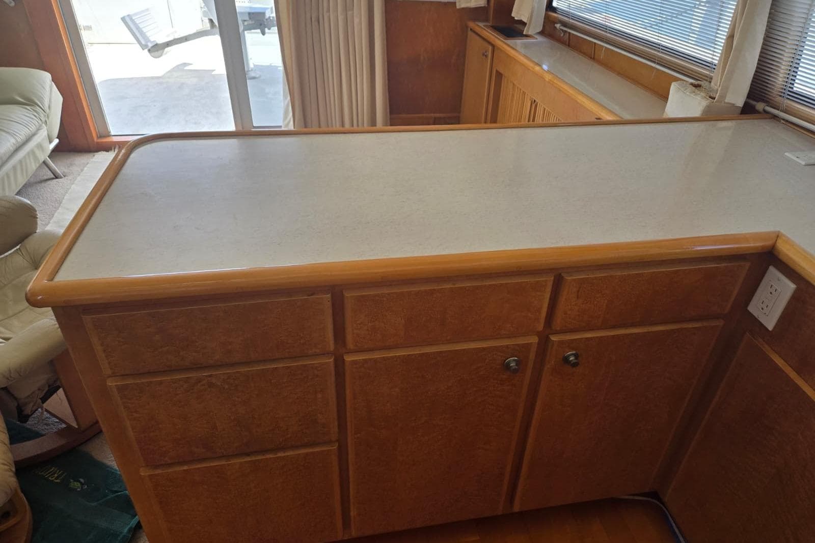 Wooden kitchen counter with cabinets in a 1994 Navigator 5600 boat interior.