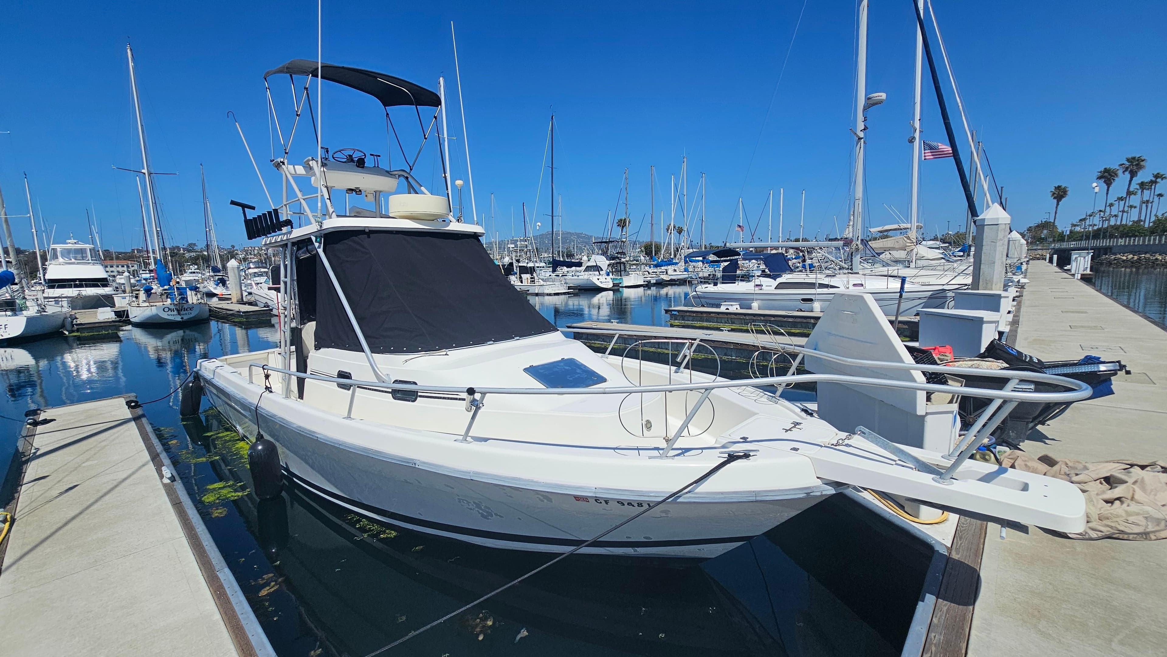 1992 Luhrs Tournament 300 boat docked in a marina under clear blue skies.