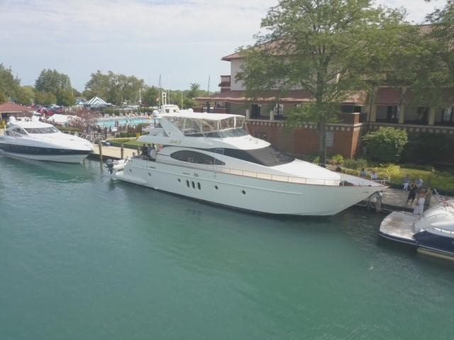 2004 Azimut 74 yacht docked by a waterfront building.