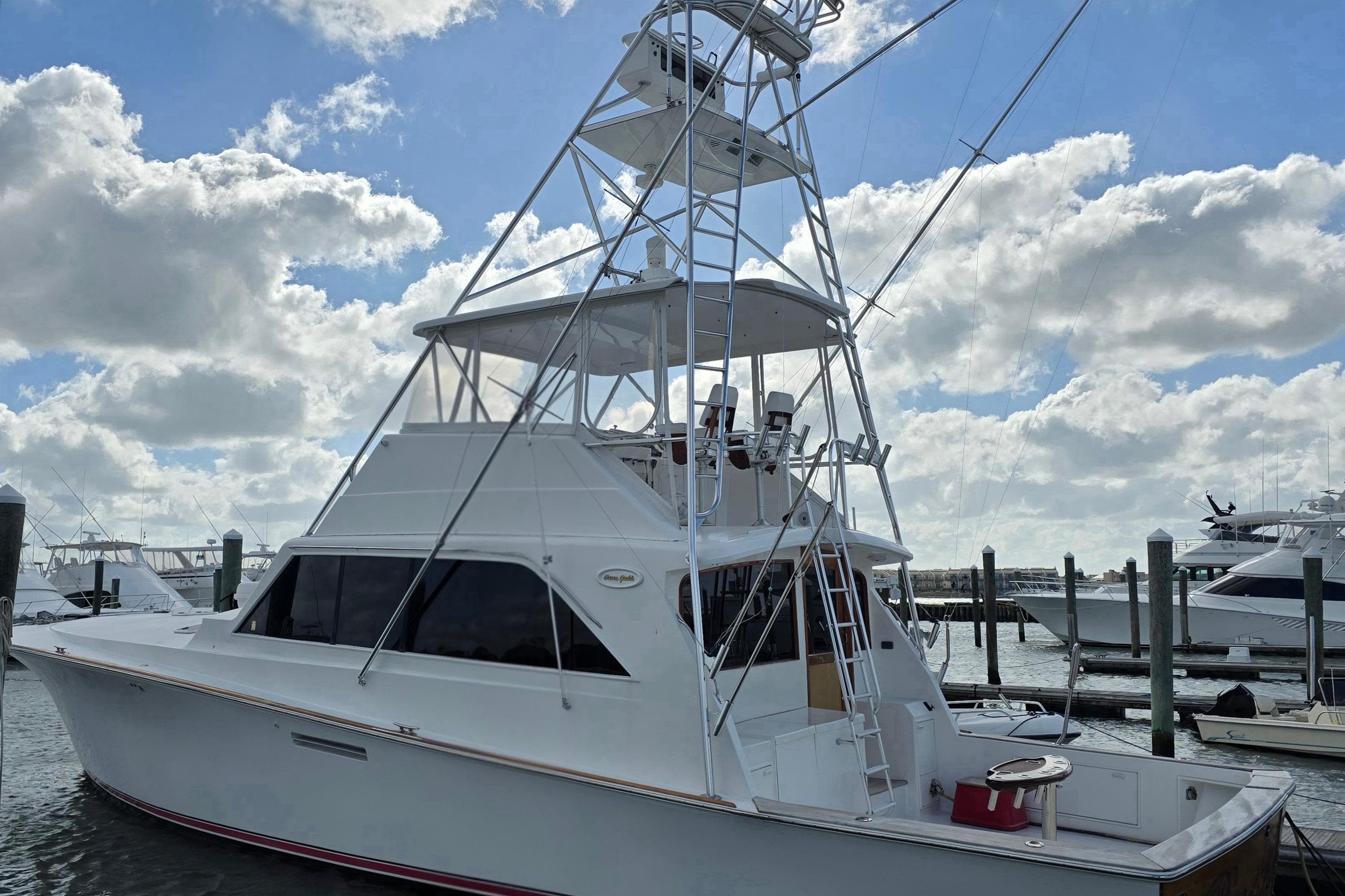Ocean Yachts 55 Super Sport 1982 model docked under a partly cloudy sky.