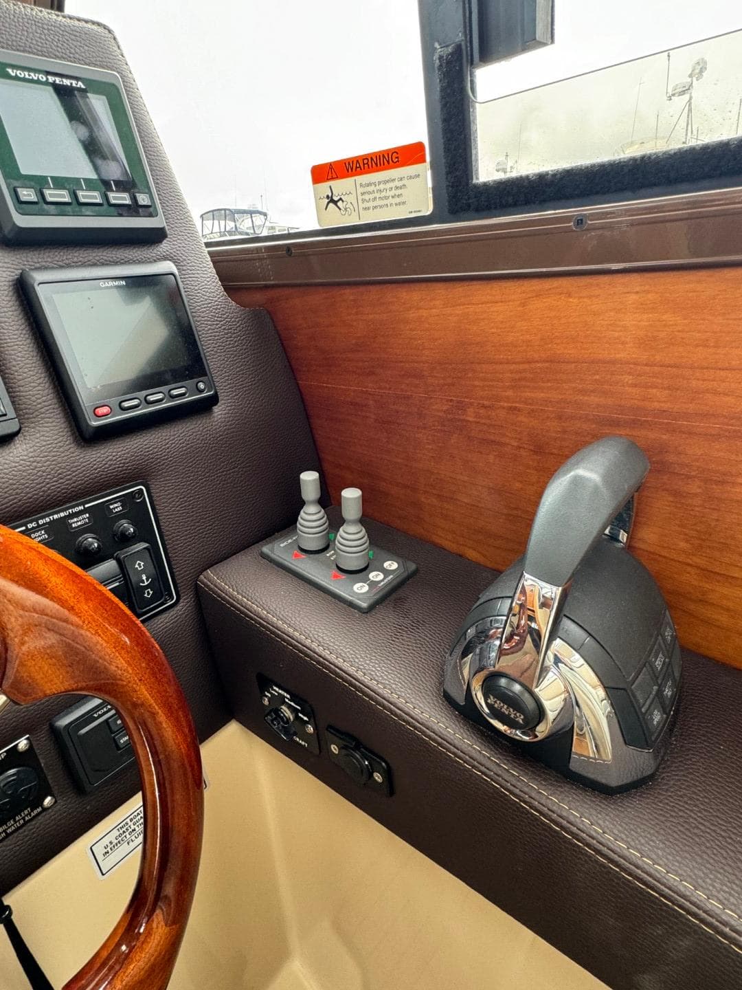 2017 Cutwater C28 helm with controls, wooden accents, and navigation displays.