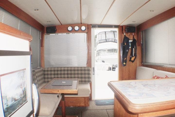 Interior of a 1992 Tollycraft 34 Sport Sedan with seating, table, and nautical decor.