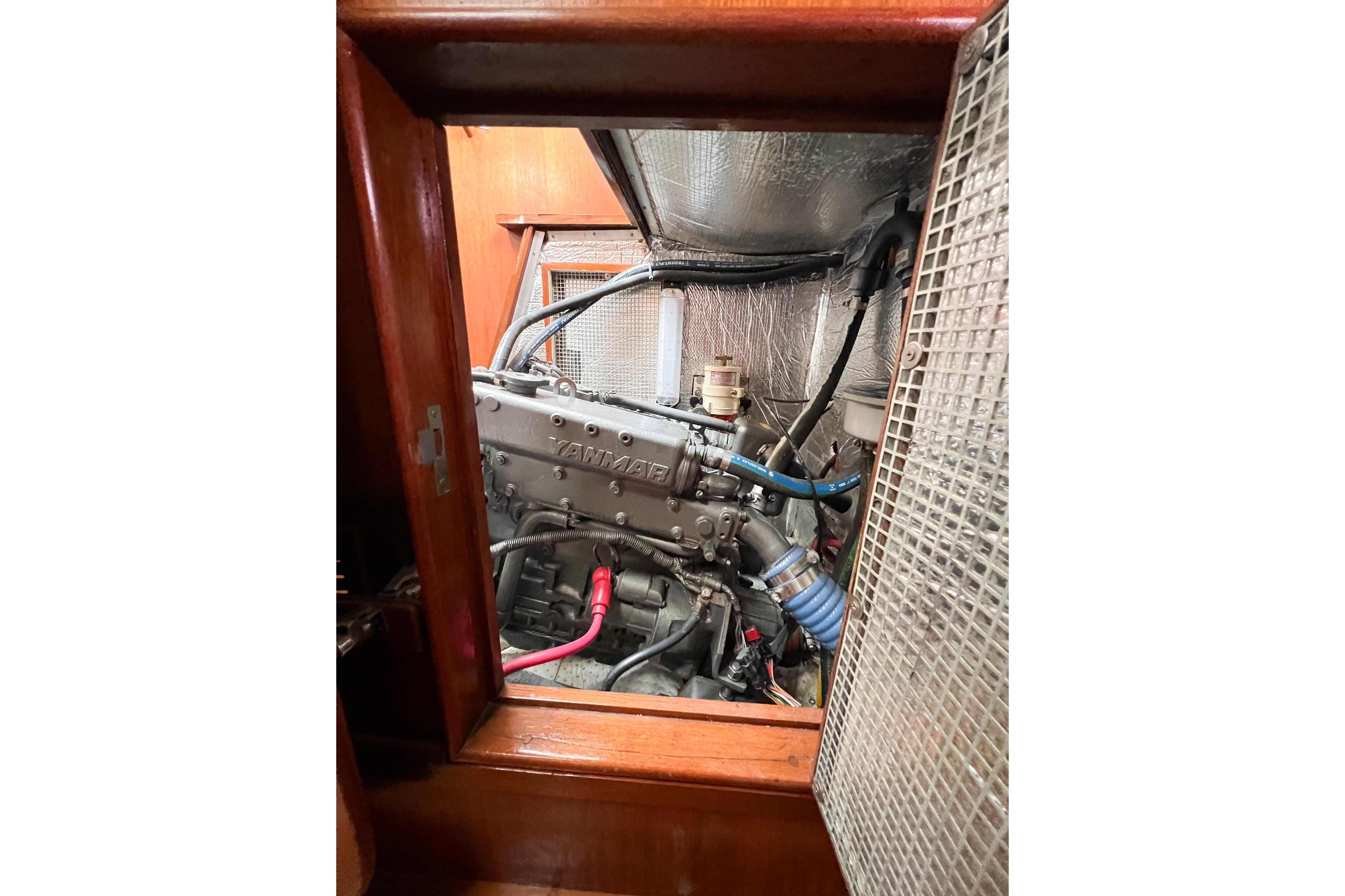 Engine compartment of a 1984 Trintella 42 sailboat, featuring a Yanmar engine.