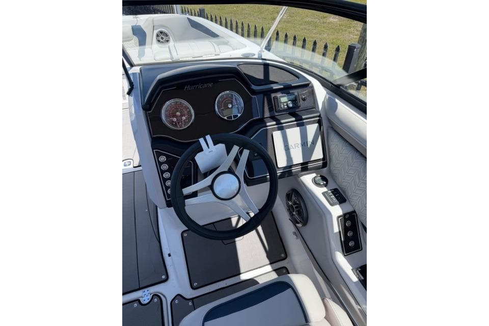 2026 Hurricane SunDeck 2600 OB boat dashboard with steering wheel and controls.