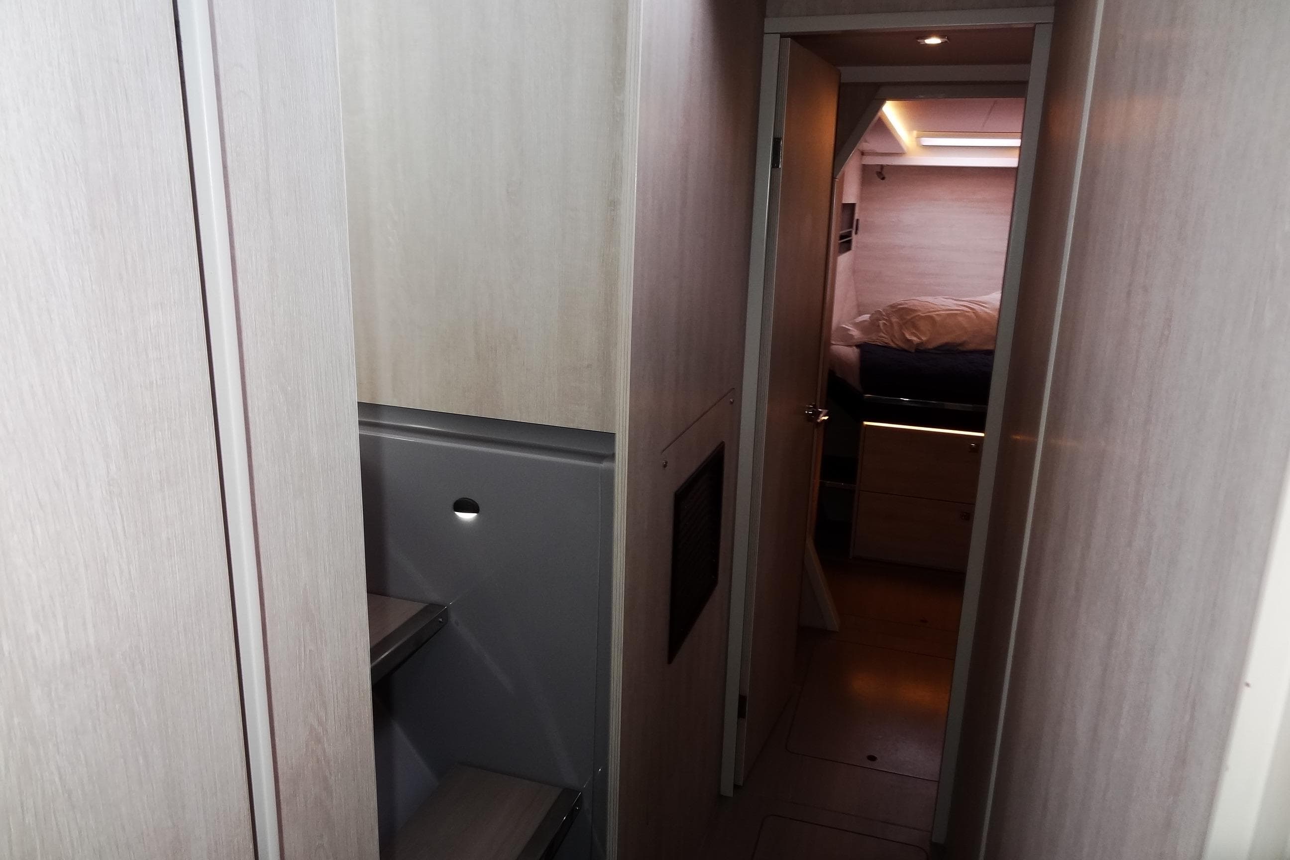 Interior hallway of a 2020 Leopard 45 yacht, leading to a cozy bedroom.