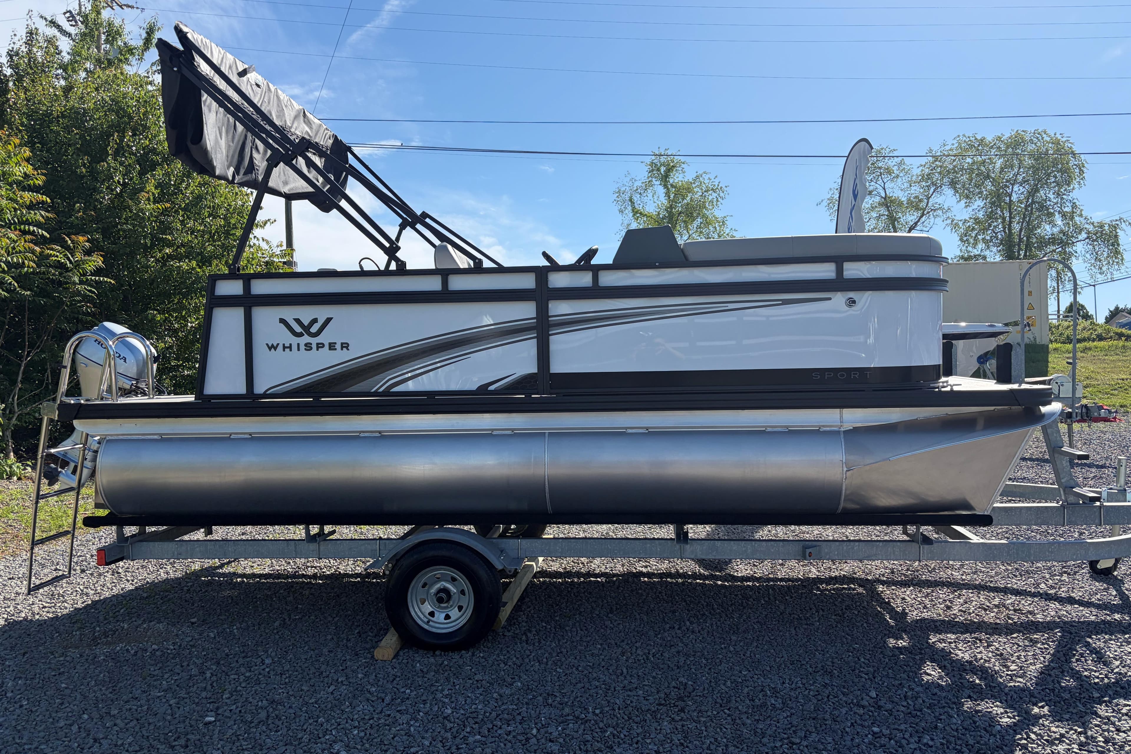 2026 Whisper S17 pontoon boat on trailer, parked outdoors under clear blue sky.
