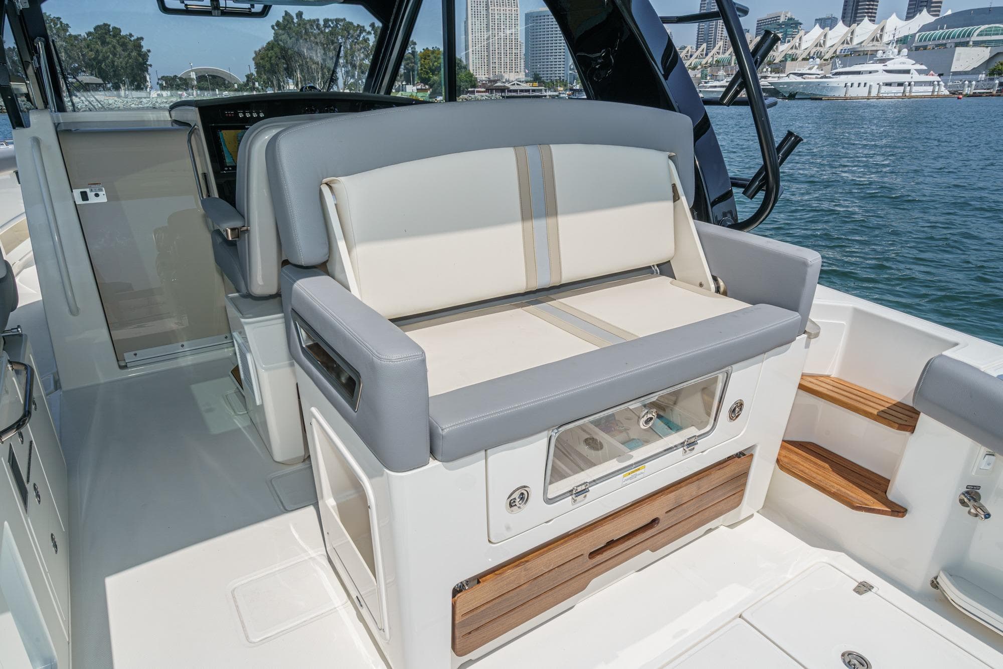 2024 Boston Whaler 380 Realm interior with seating and storage, docked by the waterfront.