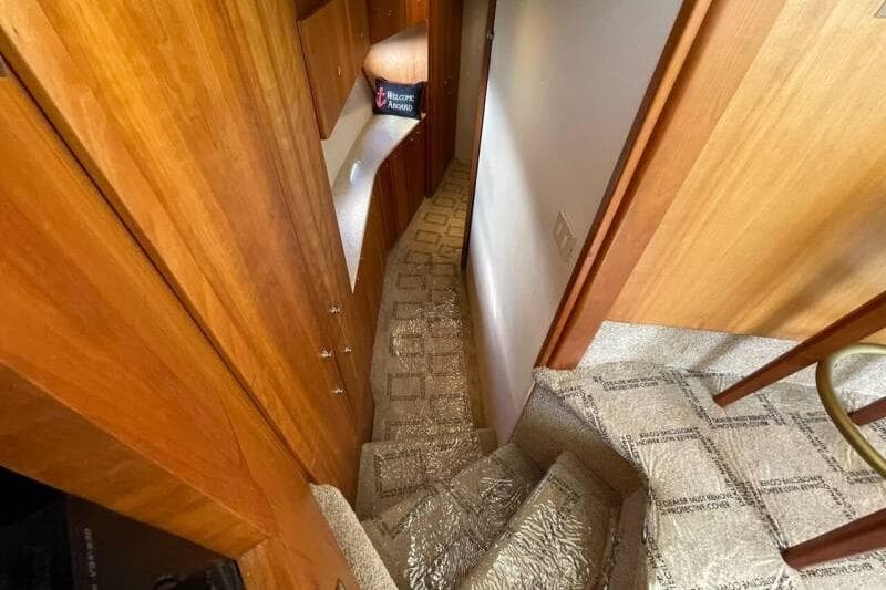 Interior view of 2000 Silverton 453 Motor Yacht, featuring carpeted stairs and wooden cabinetry.