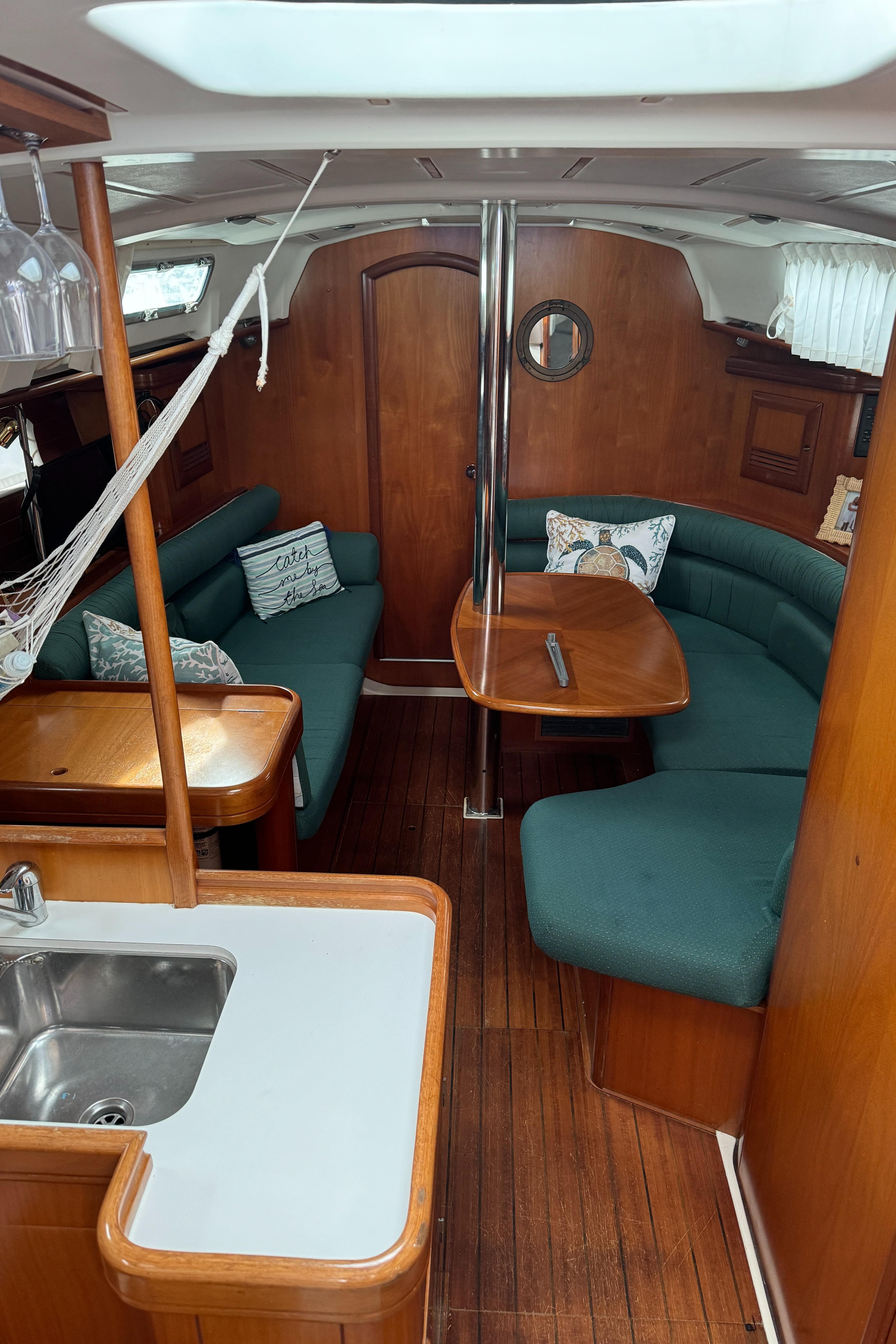 Interior of 2001 Beneteau 361 sailboat with wood finish and green seating.